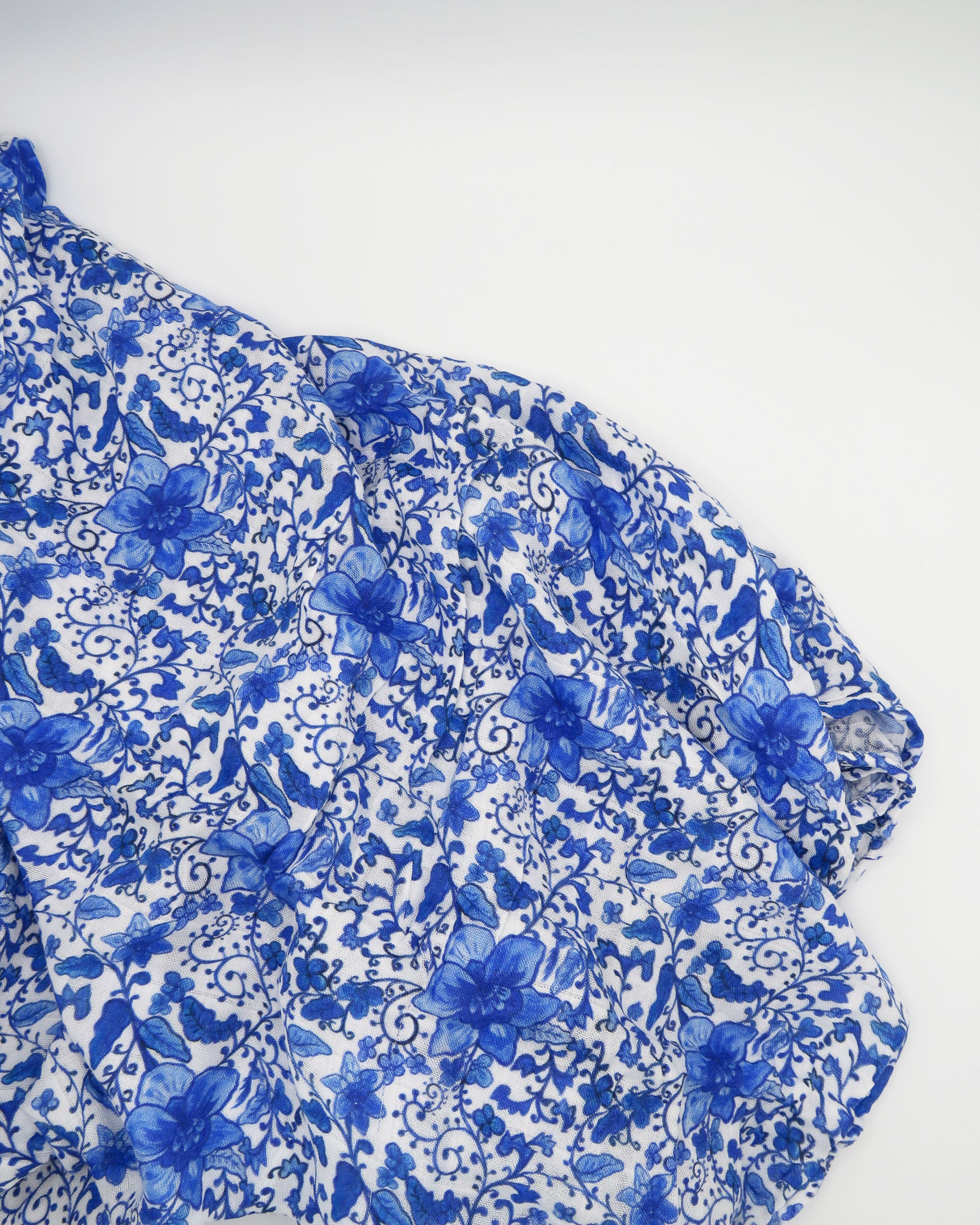 Charming newborn gown and matching hat featuring a timeless Chinoiserie print on soft white fabric, perfect for special newborn moments.