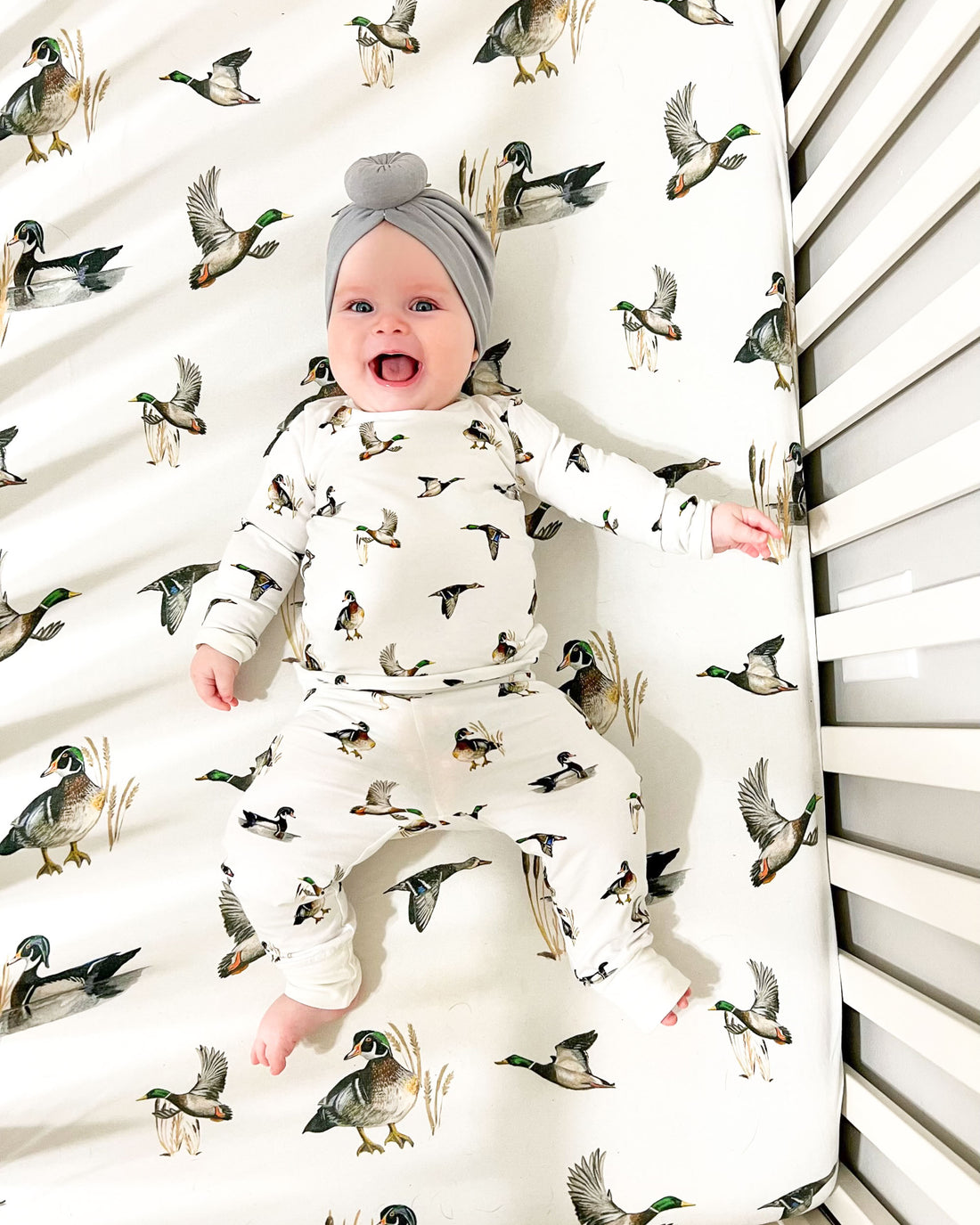 Soft cotton crib sheet with playful diving ducks pattern, perfect for a cozy duck-themed nursery.