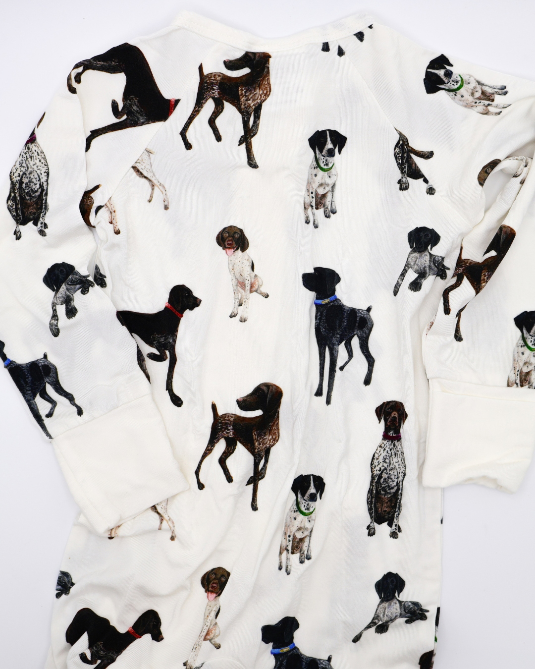 German Shorthaired Pointers pattern convertible zip footies, printed on soft white fabric. Shown displayed flat on a white background.