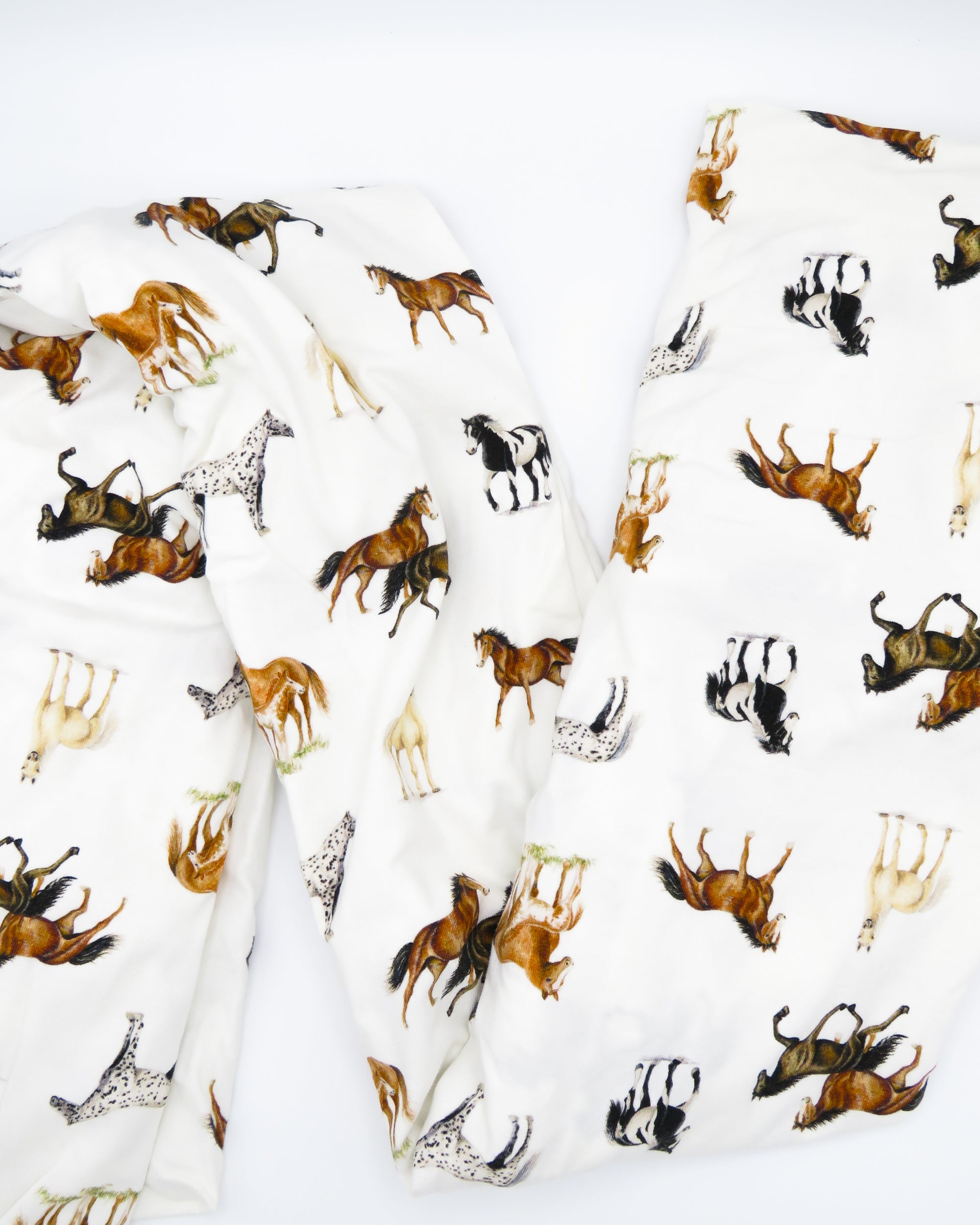 Our Harbor Horses” crib sheet featuring hand-painted, colorful horses printed on soft white 100% cotton jersey, fitted for cribs or toddler beds, perfect for a horse-themed nursery.