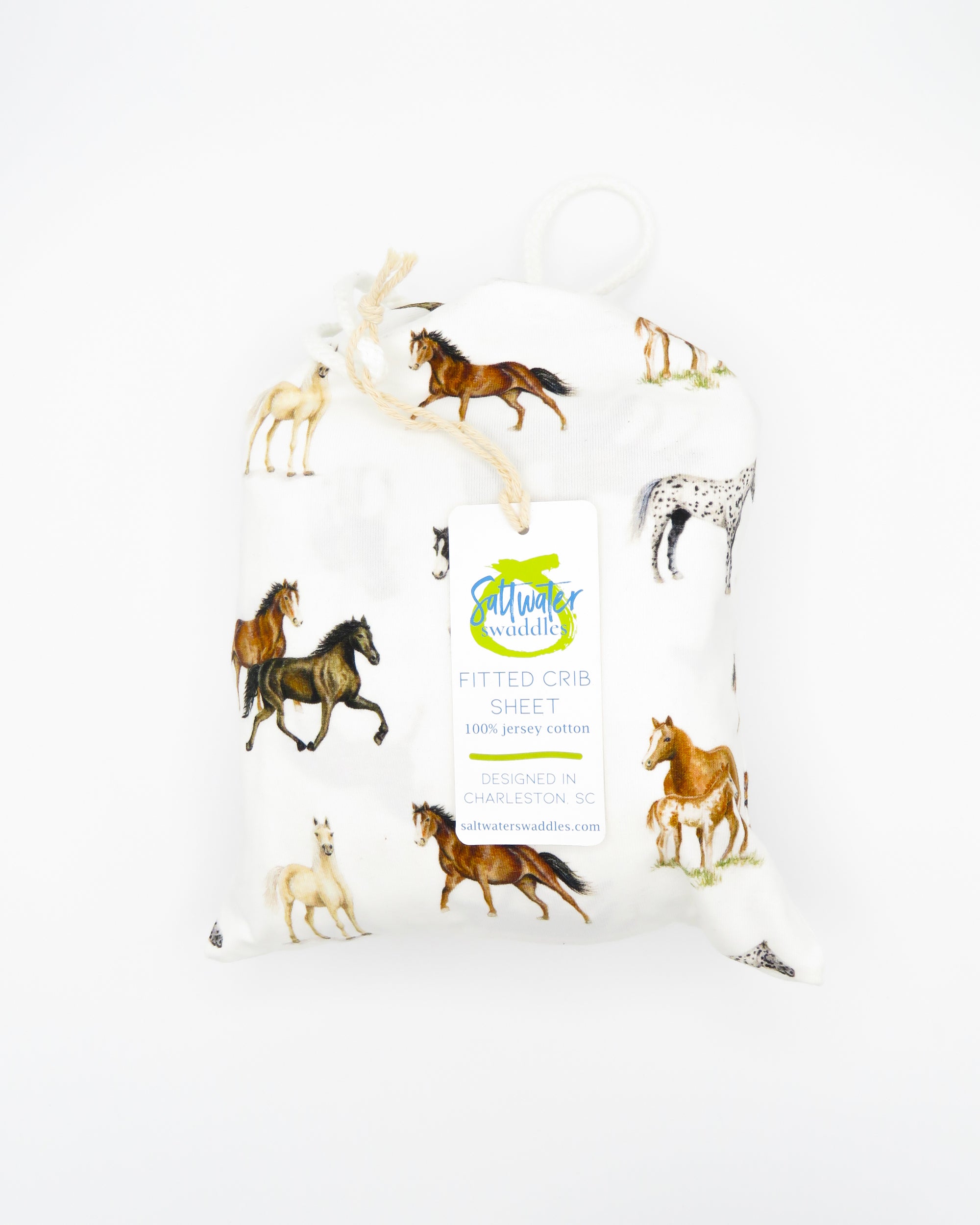 Our Harbor Horses crib sheet featuring hand-painted, colorful horses printed on soft white 100% cotton jersey, fitted for cribs or toddler beds, perfect for a horse-themed nursery.