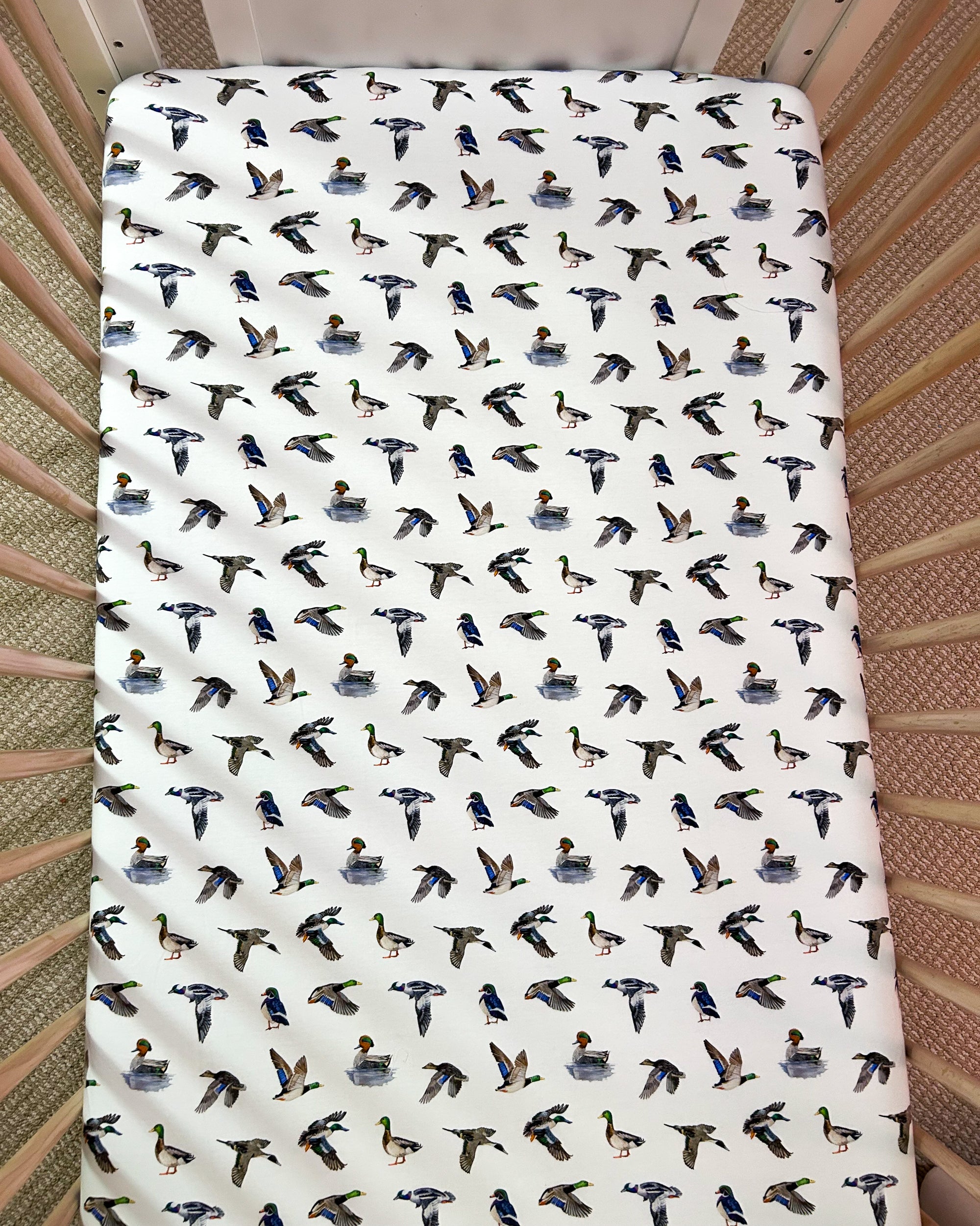 Adorable duck pattern crib sheet in soft colors, great for a gender-neutral duck-themed nursery.