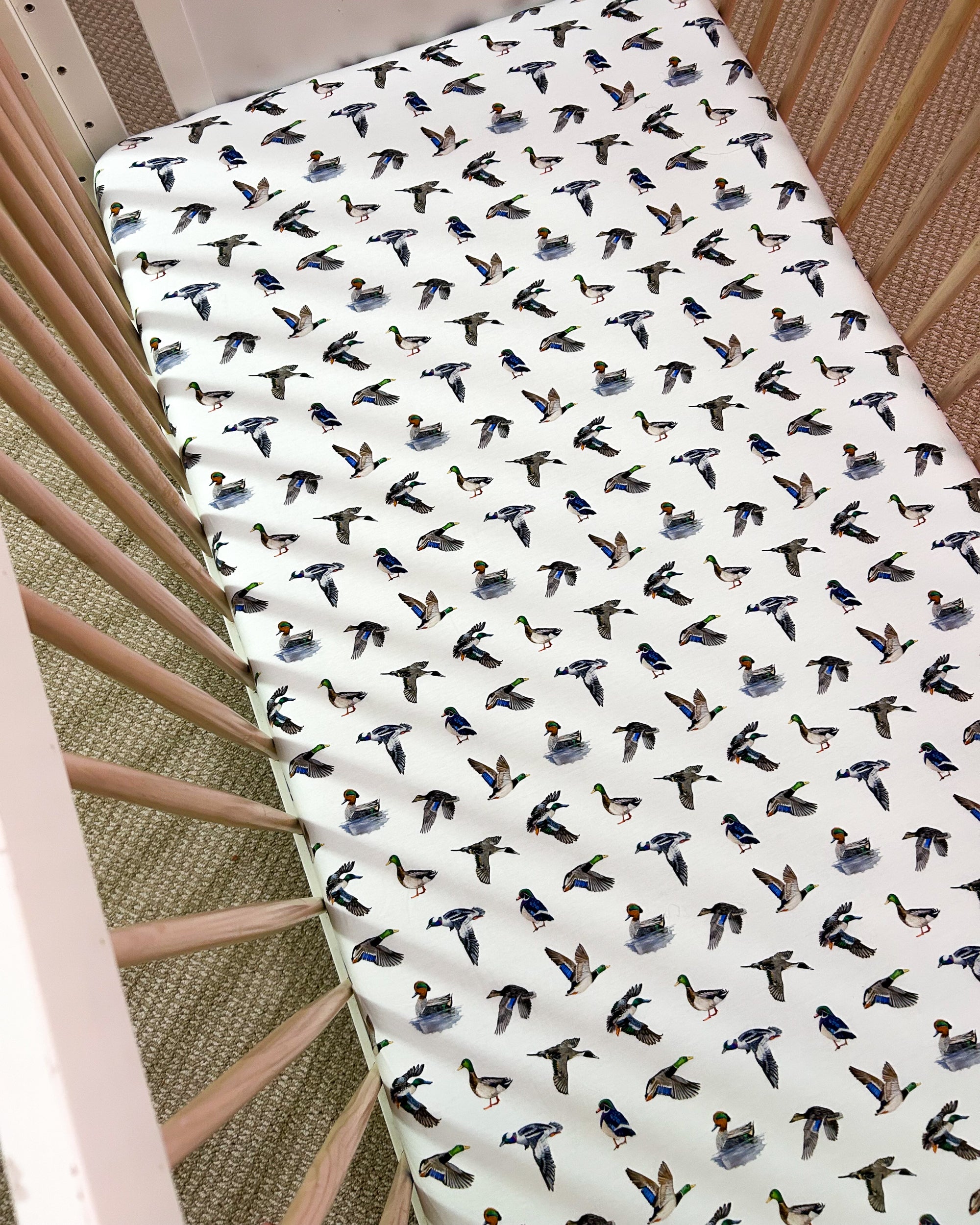 Adorable duck pattern crib sheet in soft colors, great for a gender-neutral duck-themed nursery.