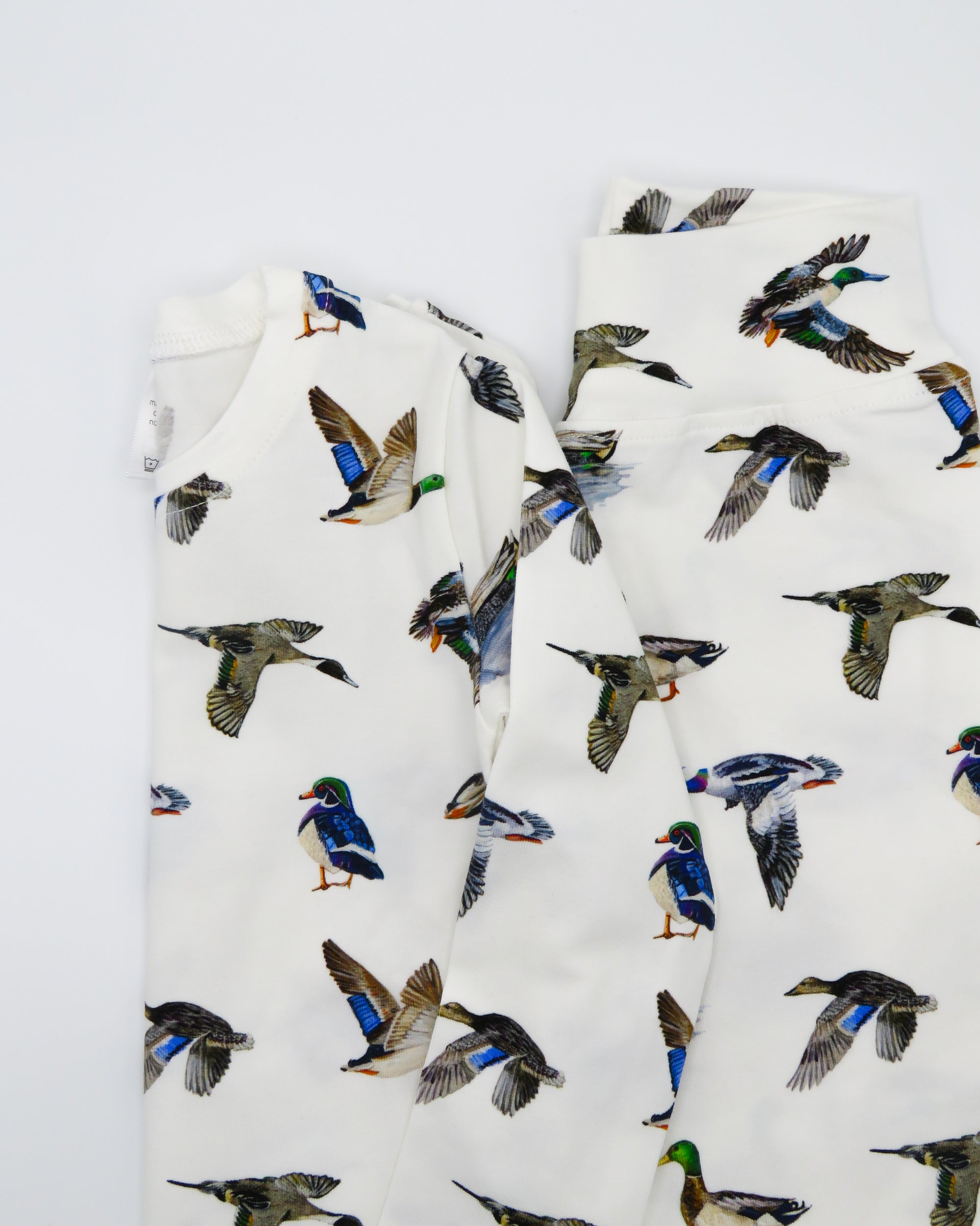 Two-piece duck print pajama set for kids made from soft, breathable fabric.