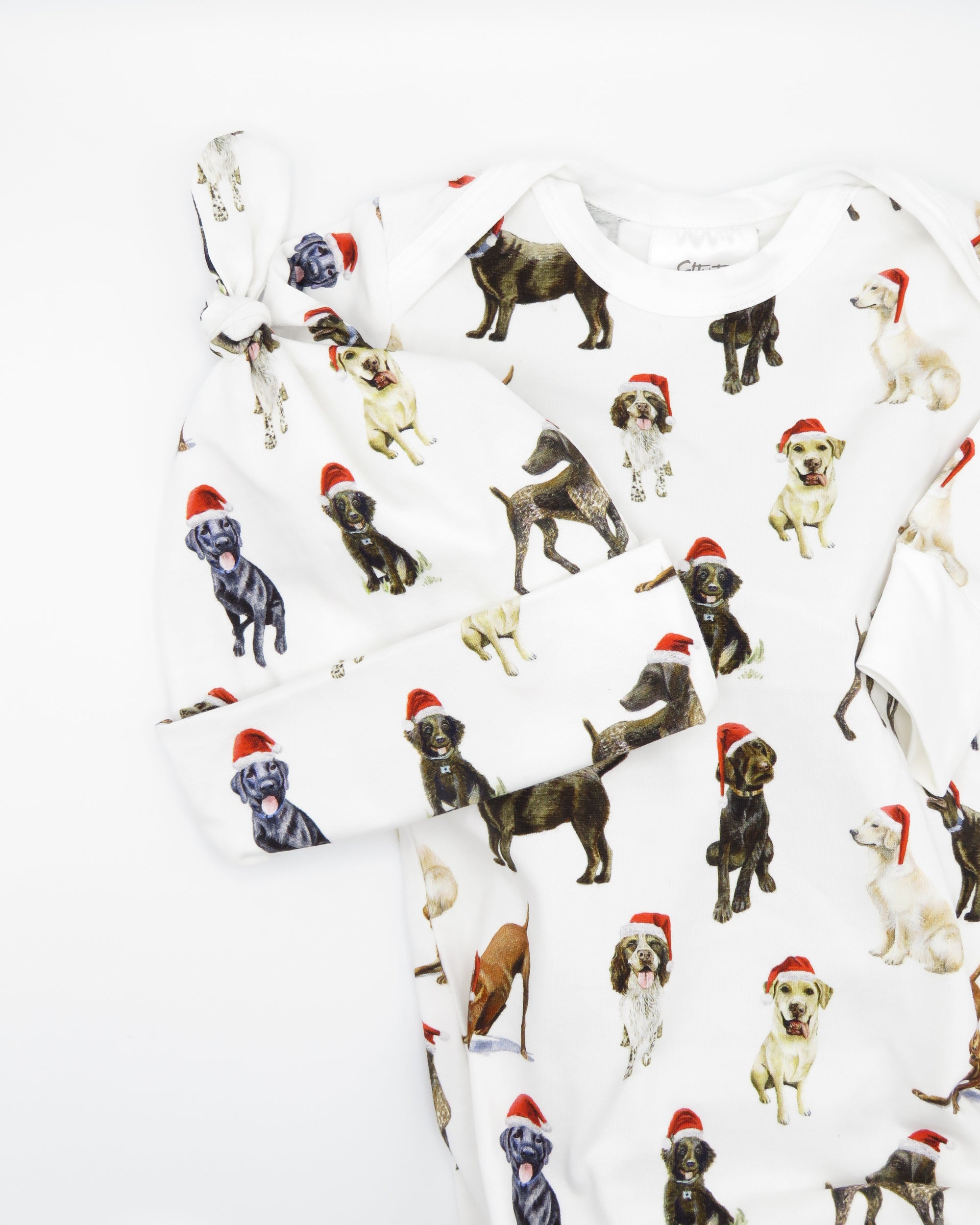 Comfy newborn gown and hat set featuring cute Santa dog prints, perfect for baby’s first Christmas