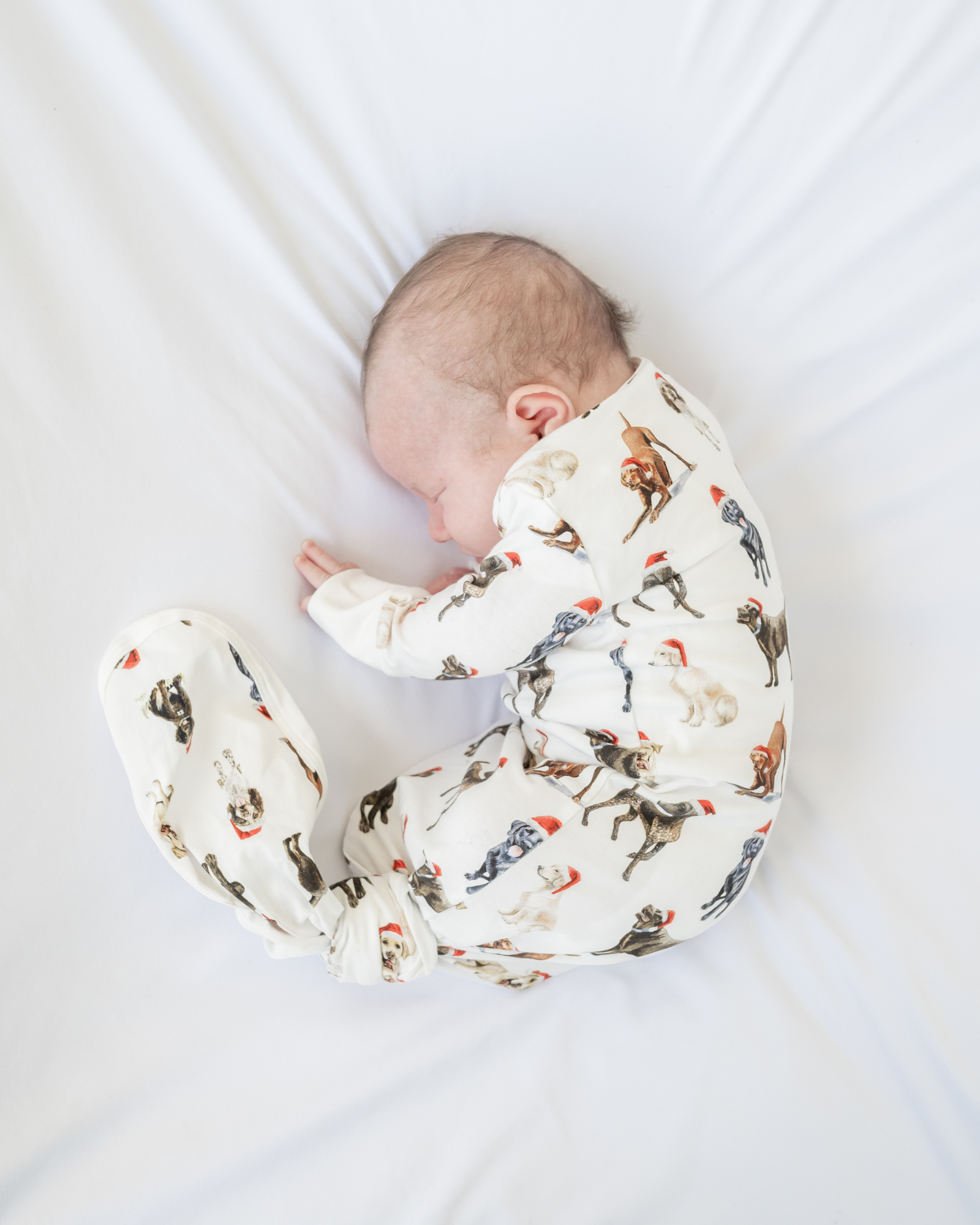 Comfy newborn gown and hat set featuring cute Santa dog prints, perfect for baby’s first Christmas
