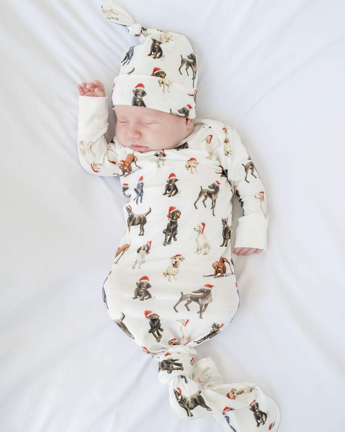 Comfy newborn gown and hat set featuring cute Santa dog prints, perfect for baby’s first Christmas
