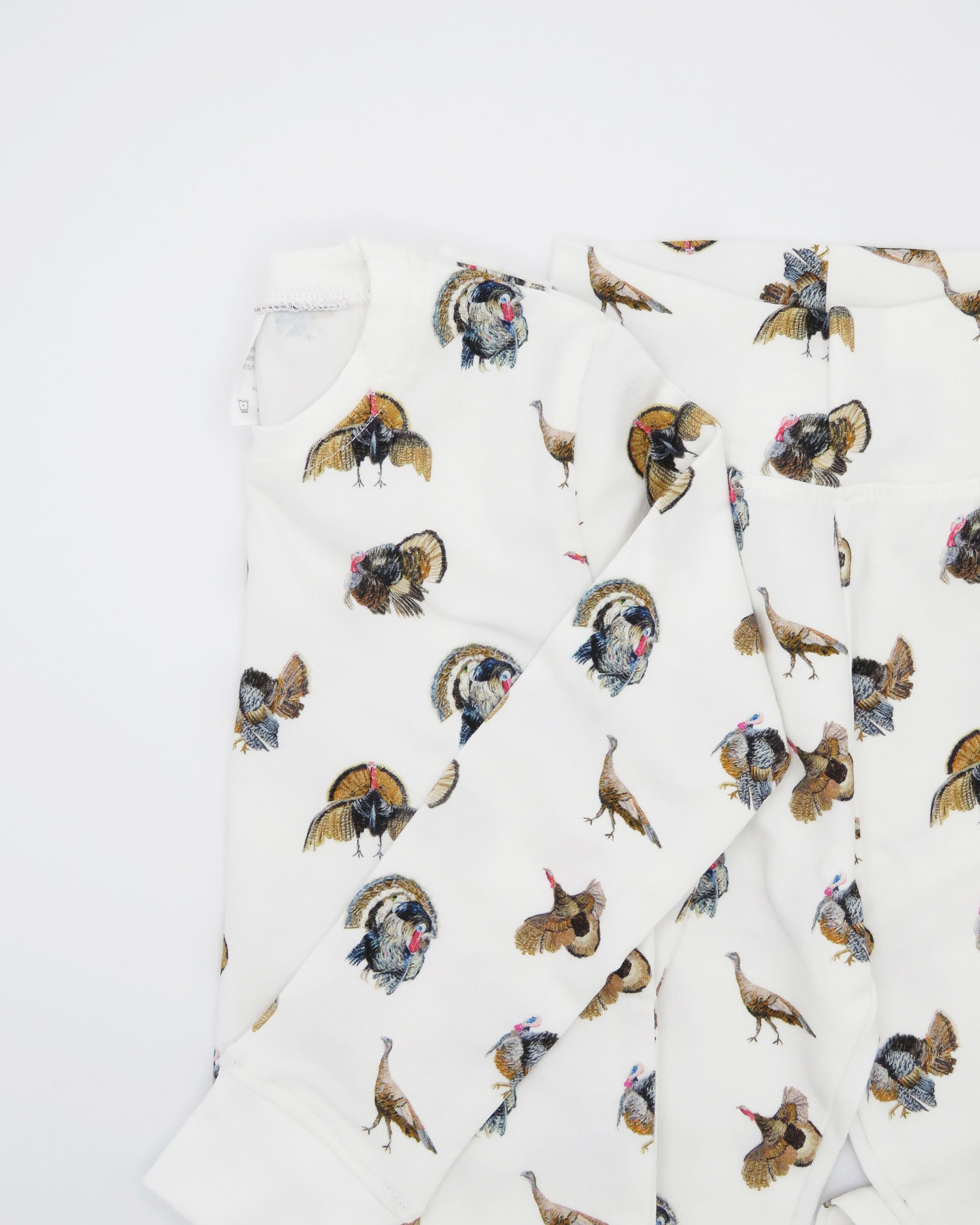 Turkey Trot print pajama for kids, high-quality, cozy, and soft. Perfect for sleepwear or loungewear indoors and outdoors, printed on soft white fabric. Displayed flat on white background.