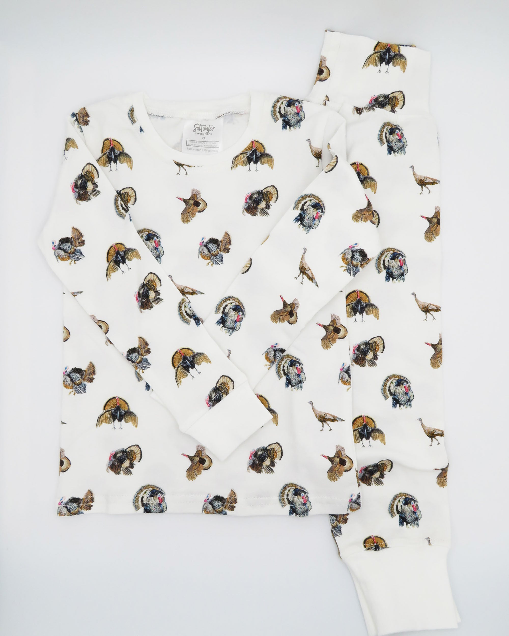 Turkey Trot print pajama for kids, high-quality, cozy, and soft. Perfect for sleepwear or loungewear indoors and outdoors, printed on soft white fabric. Displayed flat on white background.