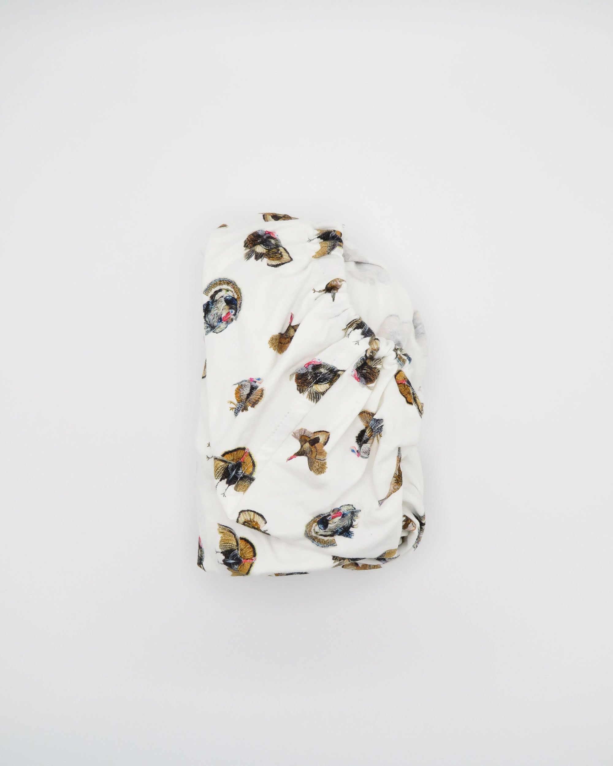 Adorable Turkey Trot crib sheet in soft white jersey cotton, featuring playful turkeys. Displayed on a white background, highlighting cozy and stylish nursery décor—perfect for a turkey-themed nursery.