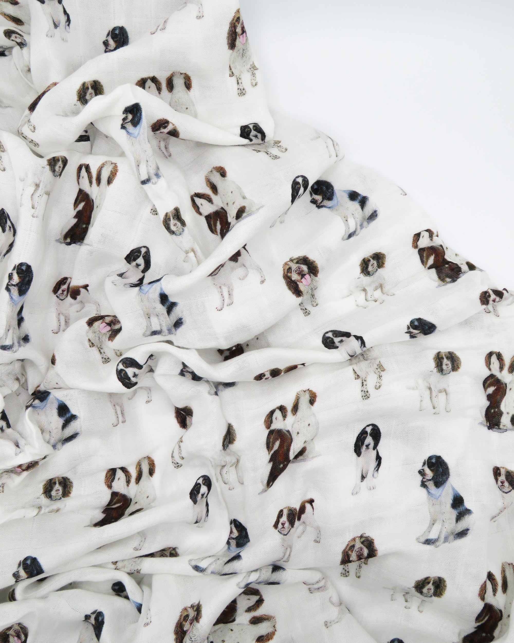 Springer Spaniel print baby swaddle blanket. Gender-neutral dog-themed swaddle for newborns. Springer Spaniel dogs printed on soft white fabric.