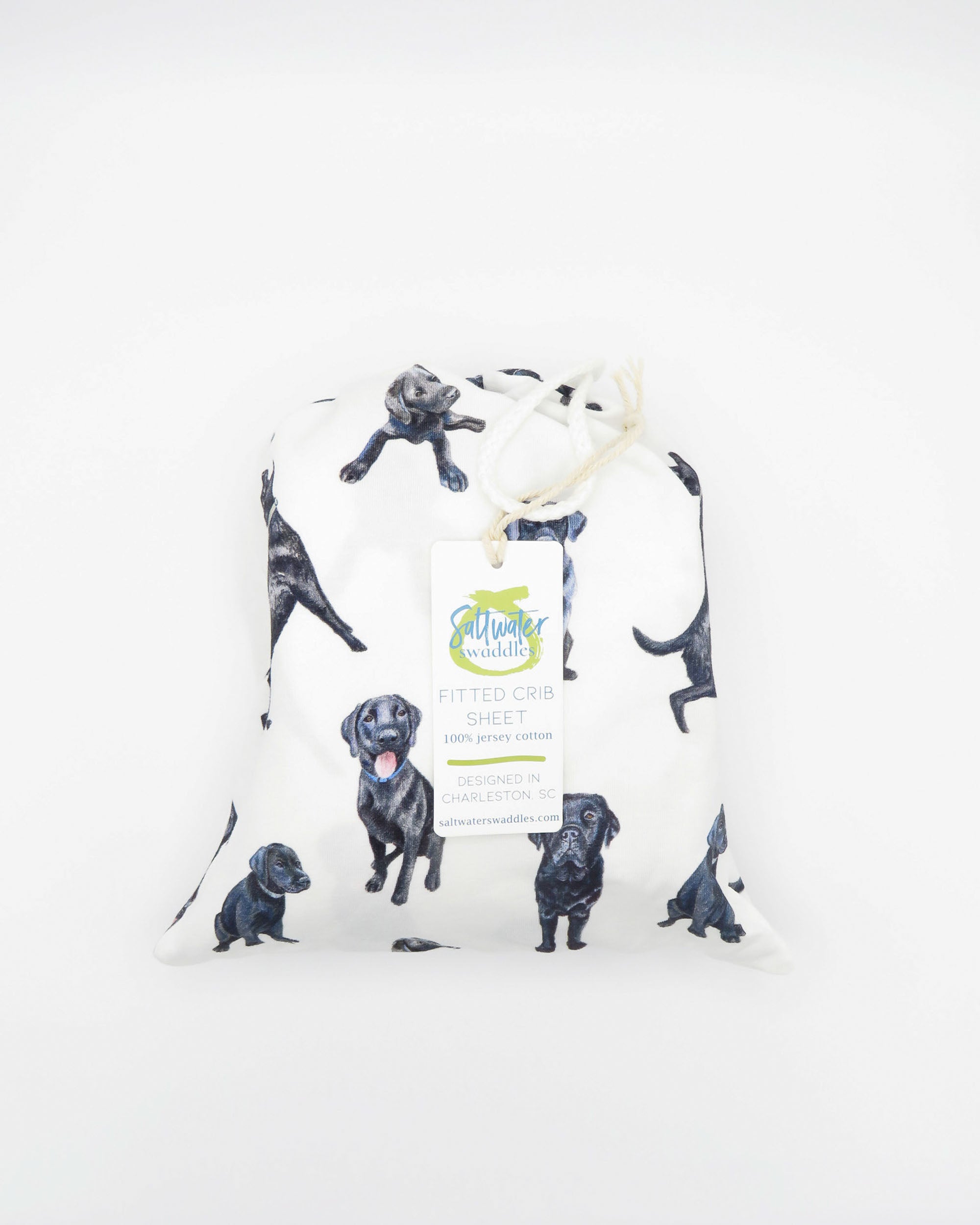 Fitted Black Lab crib sheet featuring adorable Black Labrador designs, crafted for durability and softness, printed on gentle white fabric—perfect for both cribs and toddler beds.
