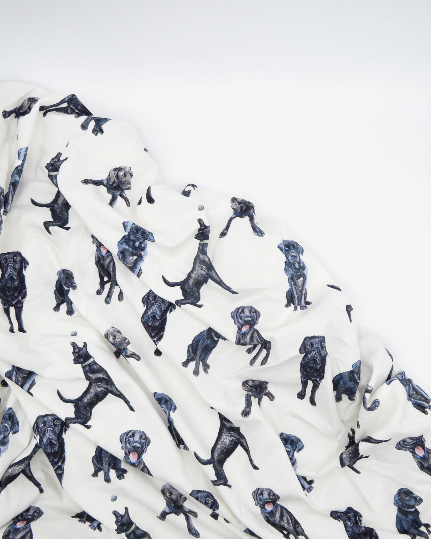 Fitted Black Lab crib sheet featuring adorable Black Labrador designs, crafted for durability and softness, printed on gentle white fabric—perfect for both cribs and toddler beds.
