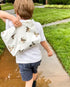 Close-up of a diving ducks pattern water-resistant white pouch showcasing its unique pattern and craftsmanship. Used by young boy outdoors for keeping his toys safe from the rain.