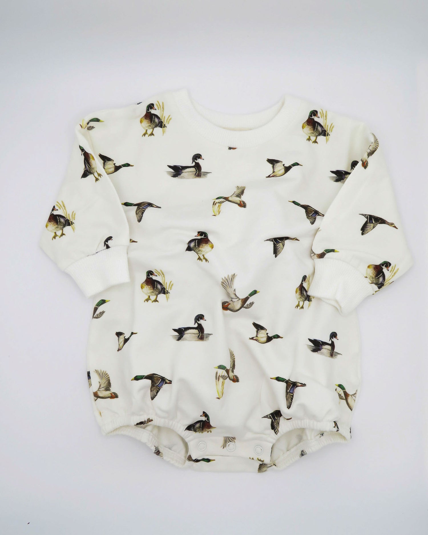 Diving Ducks print Sweatshirt Romper printed on soft white fabric. Perfect for indoors and outdoors, worn by a toddler.