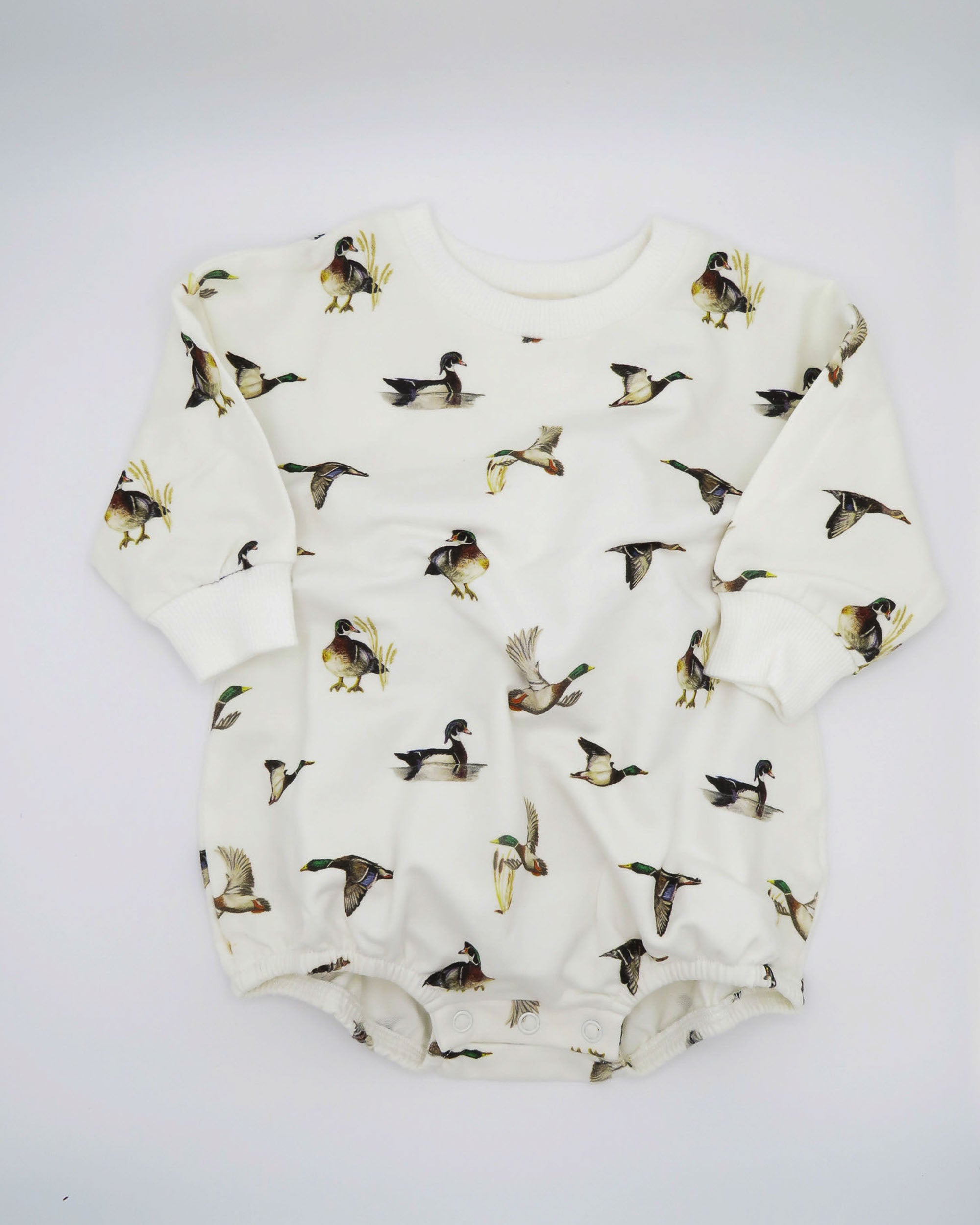 Diving Ducks print Sweatshirt Romper printed on soft white fabric. Perfect for indoors and outdoors, worn by a toddler.