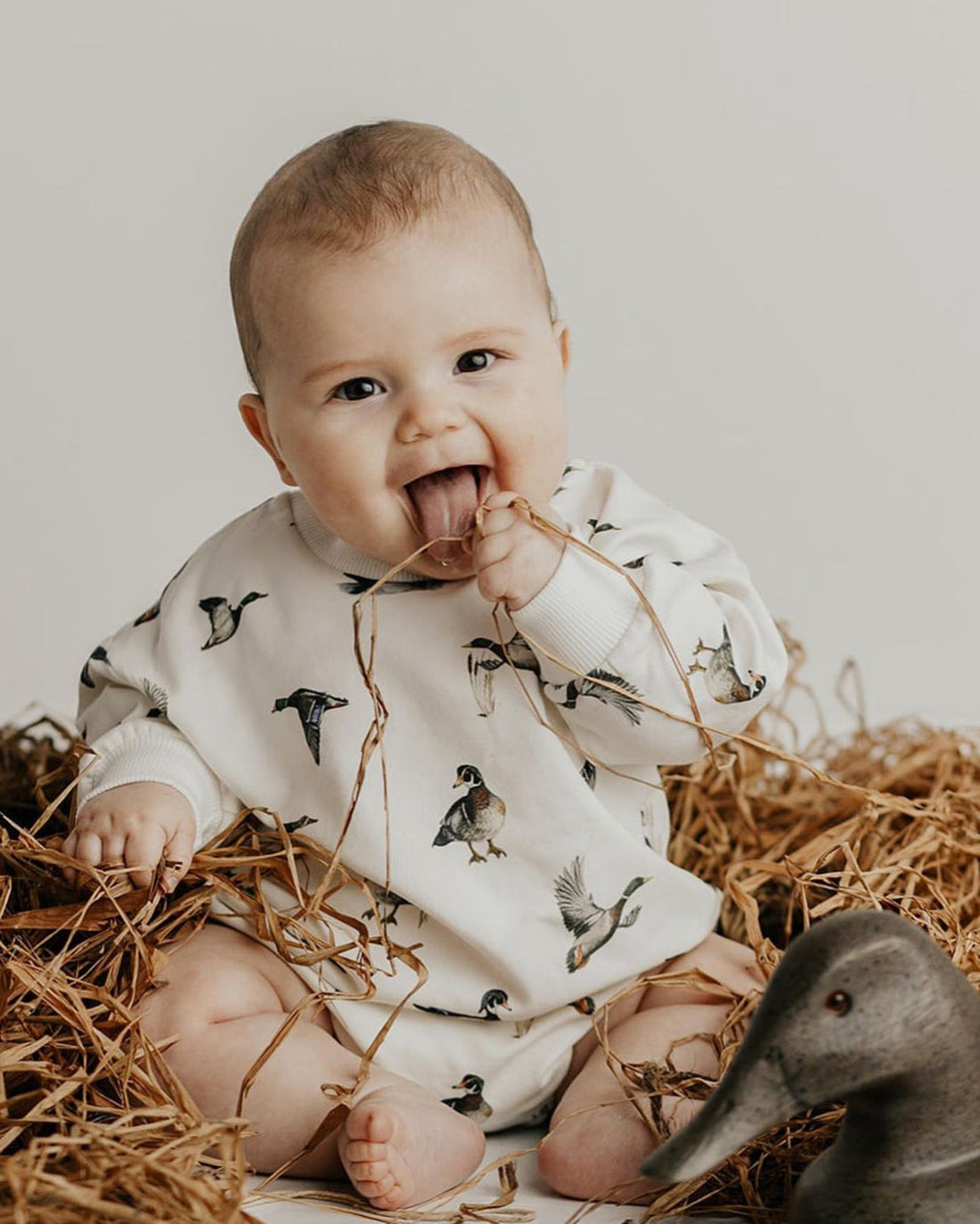 Diving Ducks print Sweatshirt Romper printed on soft white fabric. Perfect for indoors and outdoors, worn by a toddler outdoors.