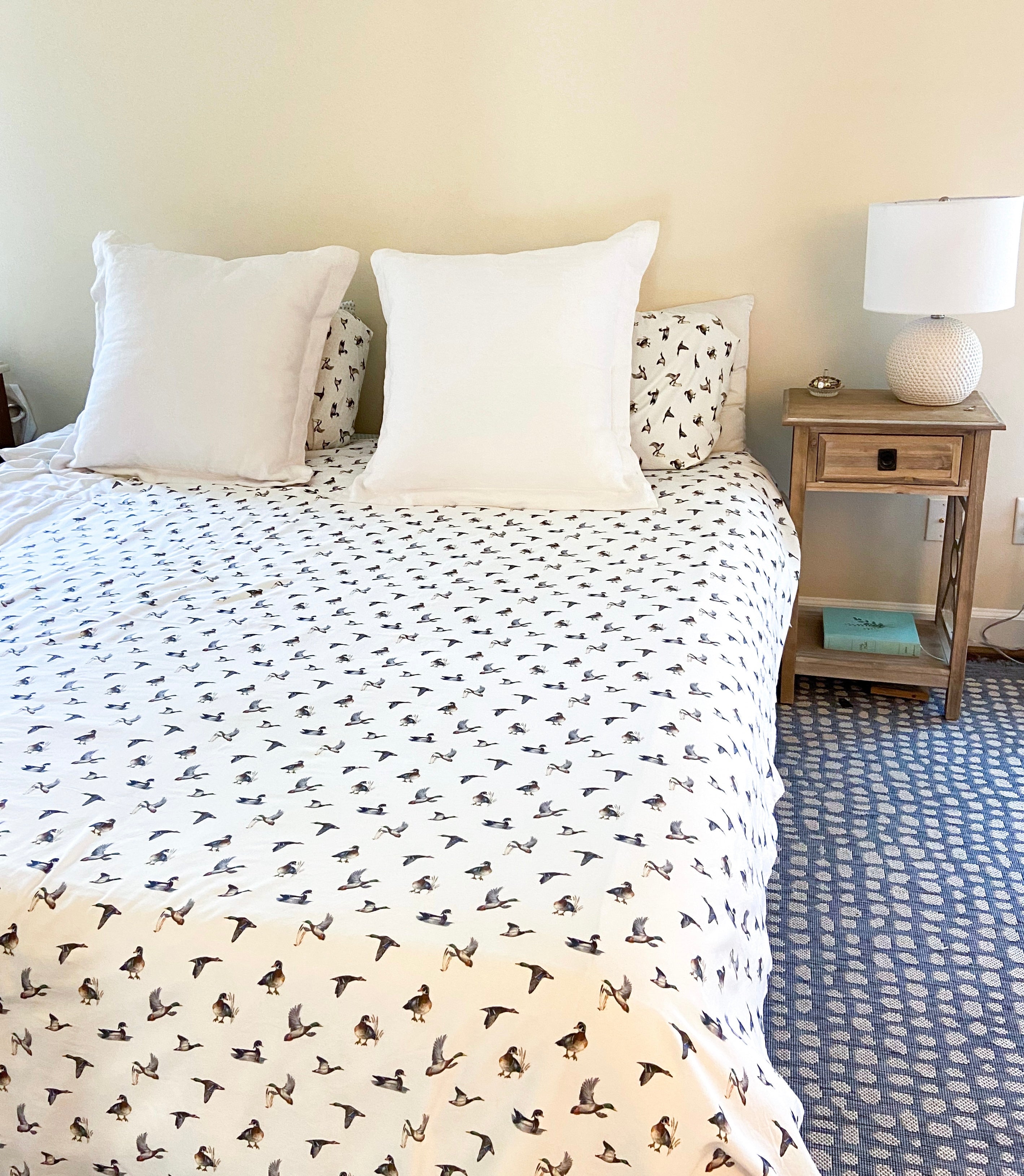 Diving ducks duvet cover on a bed. Printed on soft white fabric