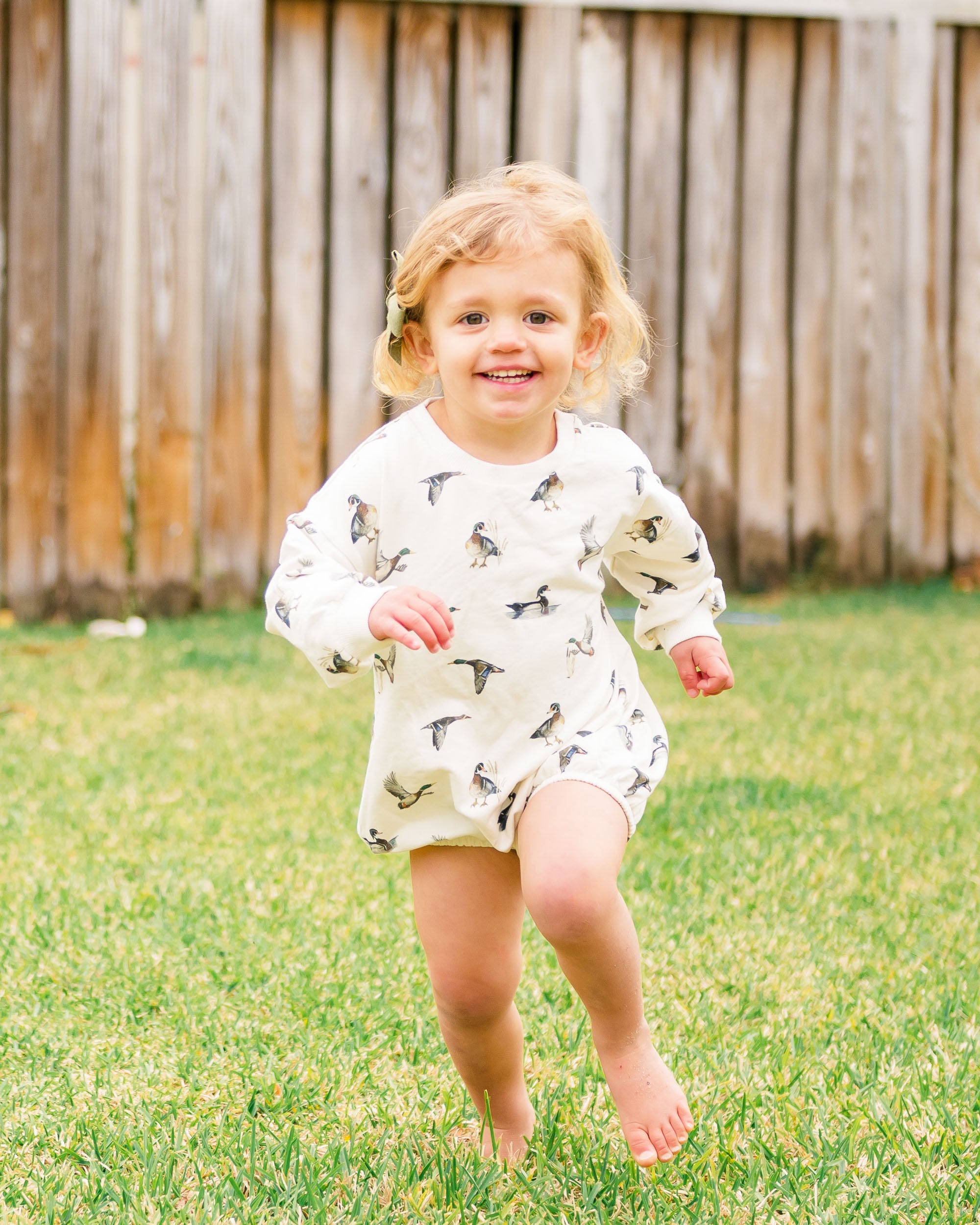 Diving Ducks print Sweatshirt Romper printed on soft white fabric. Perfect for indoors and outdoors, worn by a toddler.