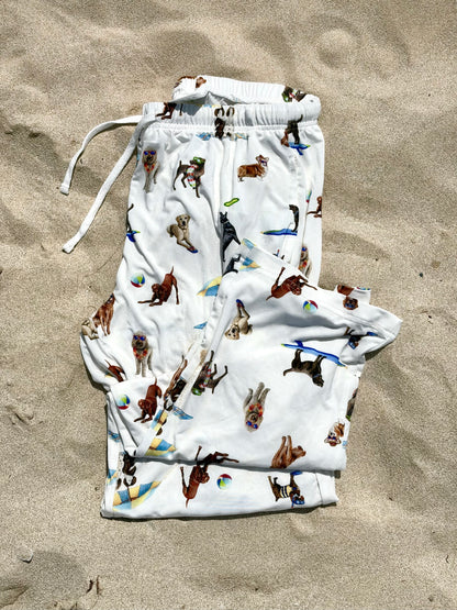 Dog Days of Summer adult pajama pants displayed folded and flat on the beach sand.