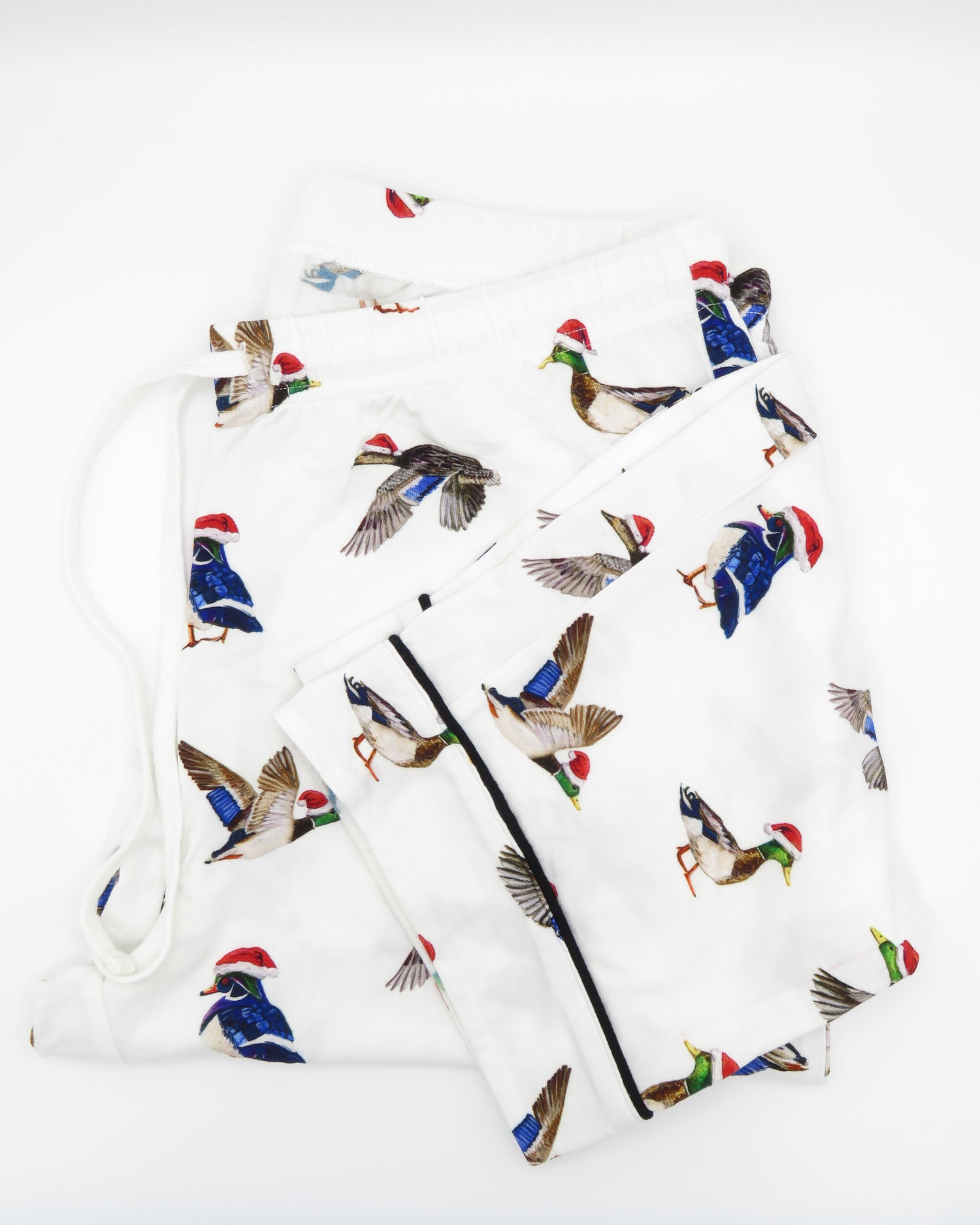 A pair of adult-sized pajama pants with a holiday pattern featuring duck the halls.