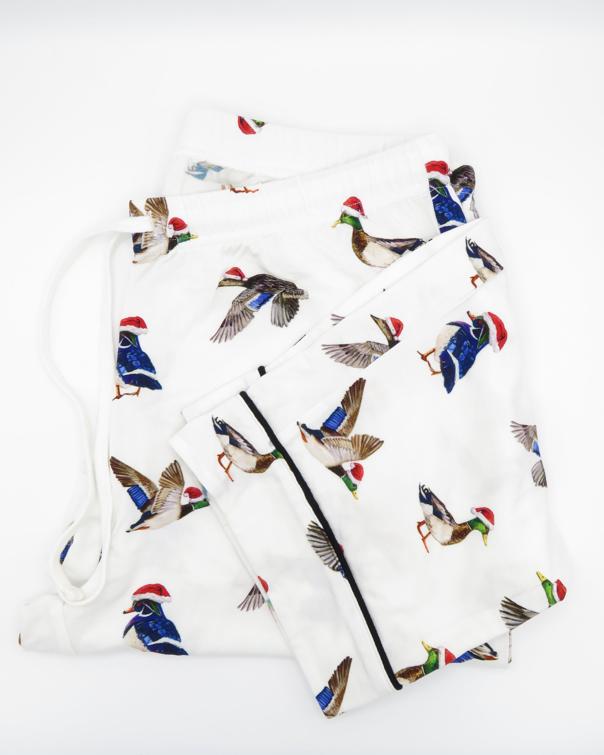 A pair of adult-sized pajama pants with a holiday pattern featuring duck the halls.