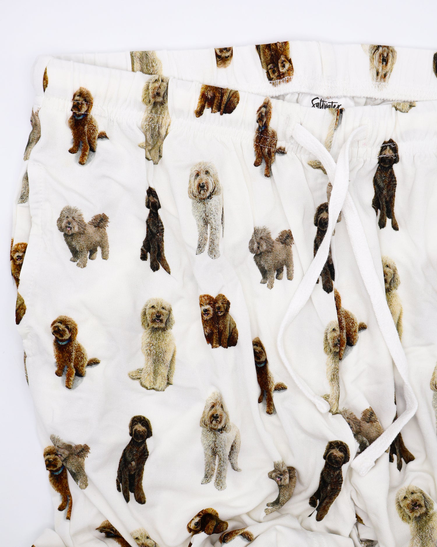 Soft white adult pajama pants featuring an all-over realistic goldendoodle pattern with an elastic waistband and white drawstring tie.