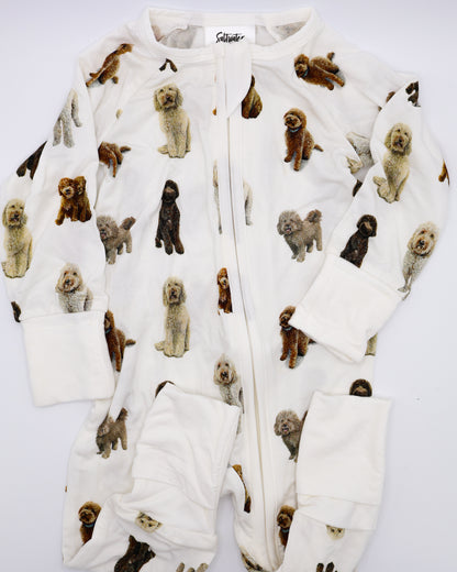 Flat-lay view of a long-sleeve goldendoodle pattern convertible zip footies, a baby romper with two-way zipper and convertible fold-over feet.