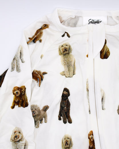 Close-up of a flat-lay view of a long-sleeve goldendoodle pattern convertible zip footies, a baby romper with two-way zipper and convertible fold-over feet.