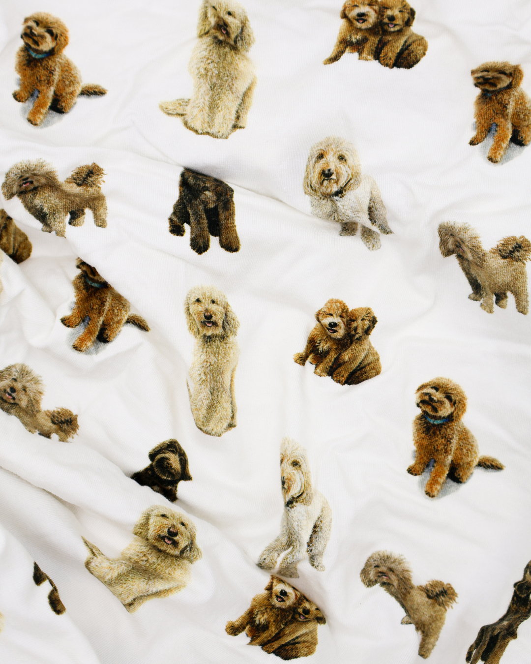 Fitted cotton crib sheet featuring an all-over goldendoodle dog pattern on a crisp white background.