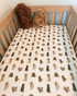 Fitted cotton crib sheet featuring an all-over goldendoodle dog pattern in a crib.