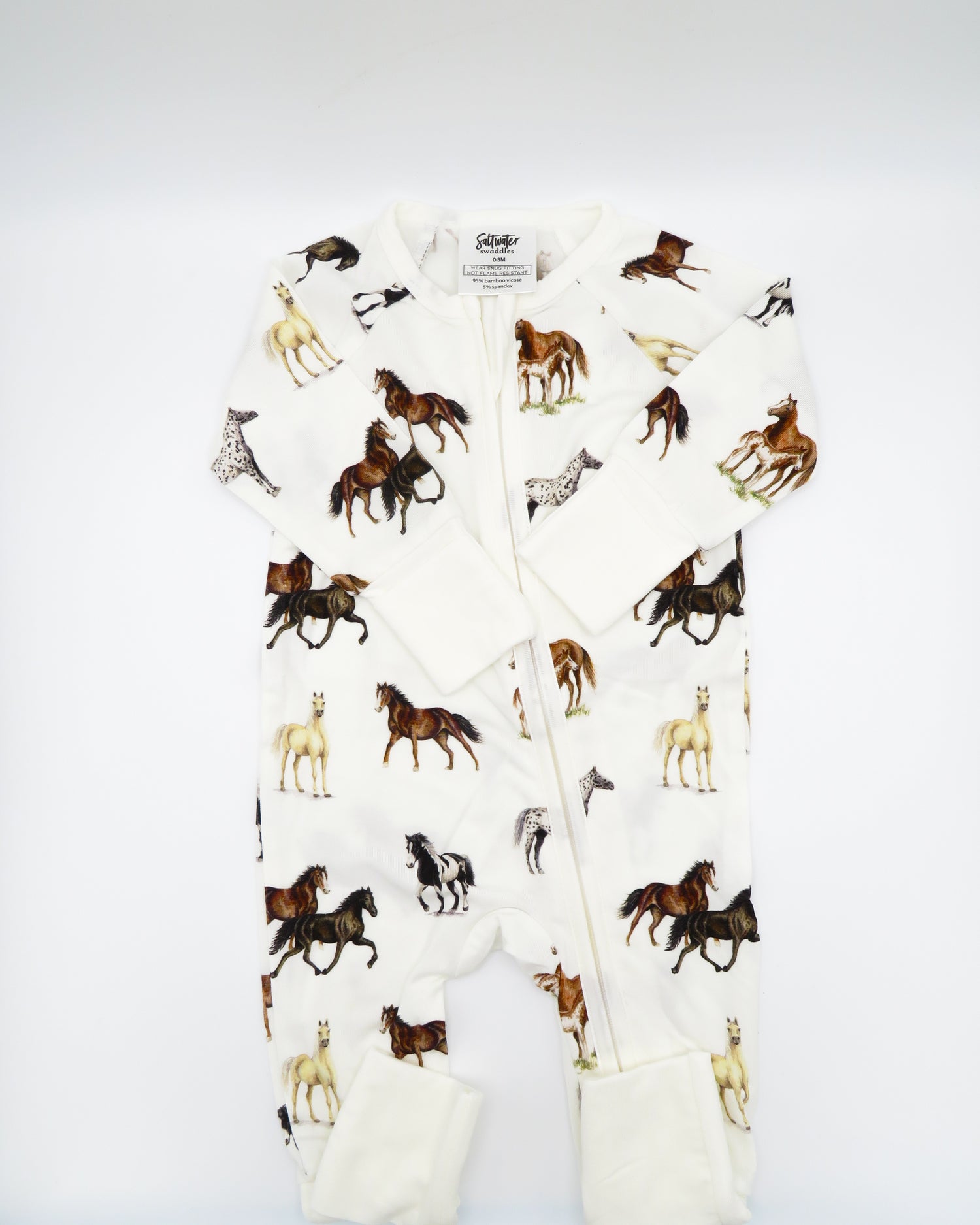Harbor Horses convertible baby zip footie pajamas with hand-painted horse designs in vibrant colors on white 100% bamboo fabric, featuring fold-over feet for comfort and convertible wear. A perfect addition to your baby essentials.