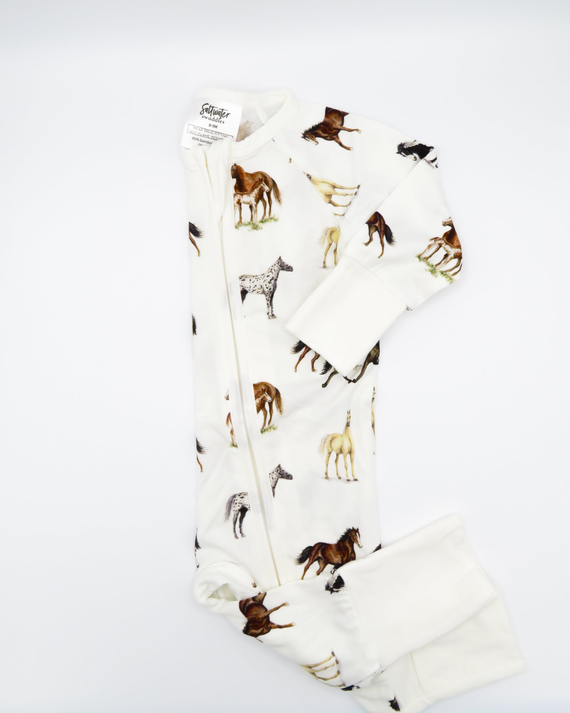 Harbor Horses convertible baby zip footie pajamas with hand-painted horse designs in vibrant colors on white 100% bamboo fabric, featuring fold-over feet for comfort and convertible wear. A perfect addition to your baby essentials.