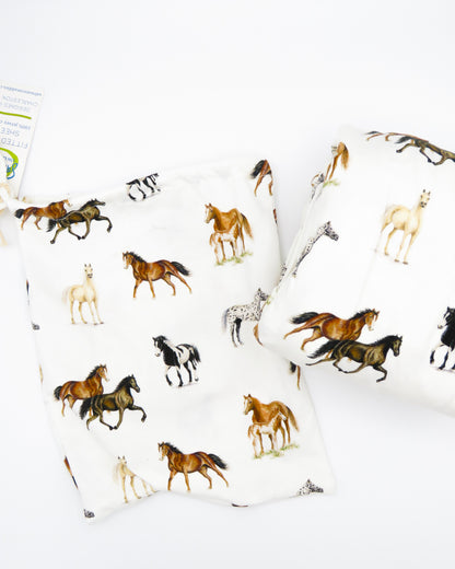 Our Harbor Horses” crib sheet featuring hand-painted, colorful horses printed on soft white 100% cotton jersey, fitted for cribs or toddler beds, perfect for a horse-themed nursery.