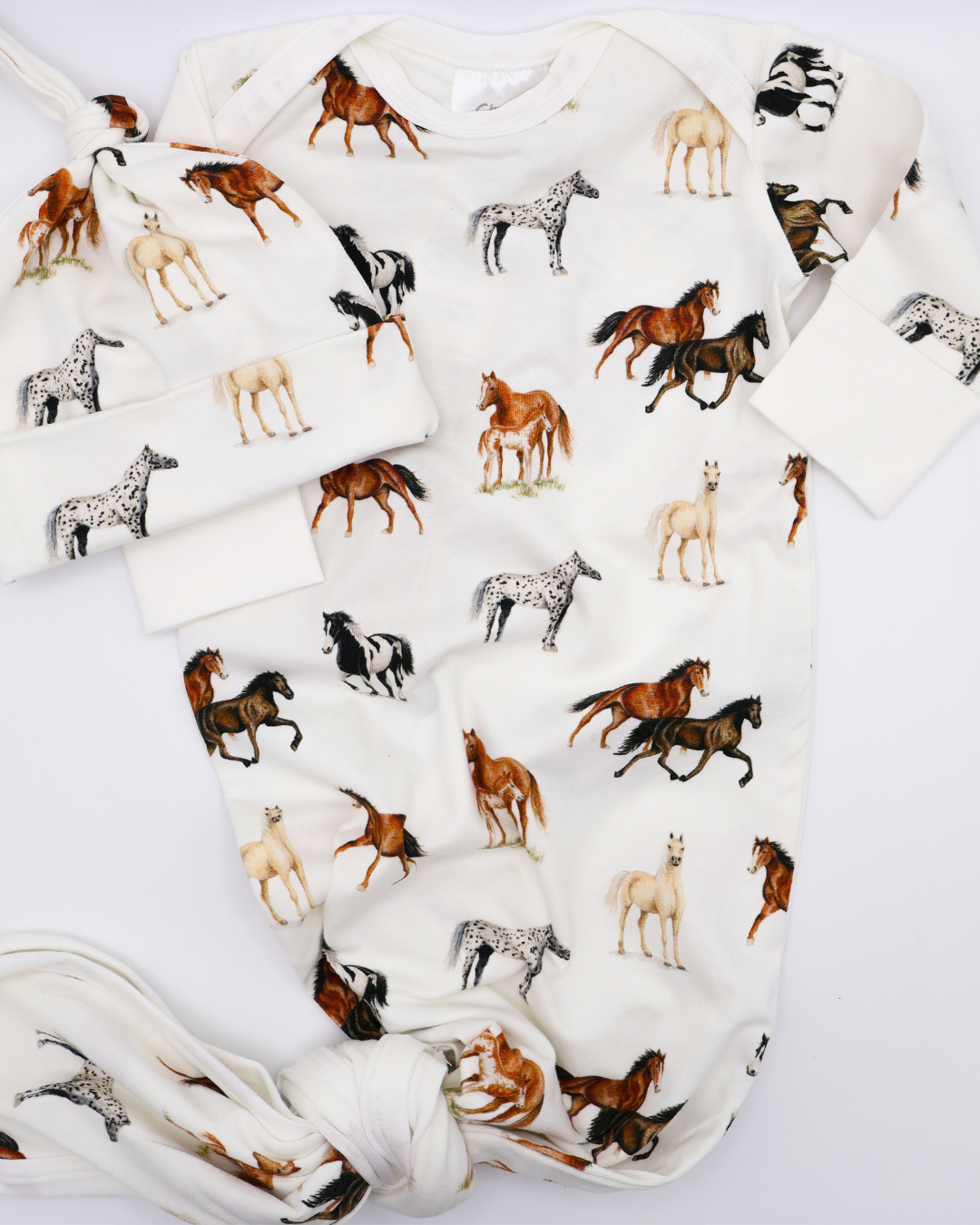 Harbor Horses Newborn Gown and Hat set printed on soft white fabric, featuring a charming harbor horses pattern. This cozy newborn outfit includes a matching hat and gown, making it a newborn’s new favorite and a perfect addition to your hospital bag..