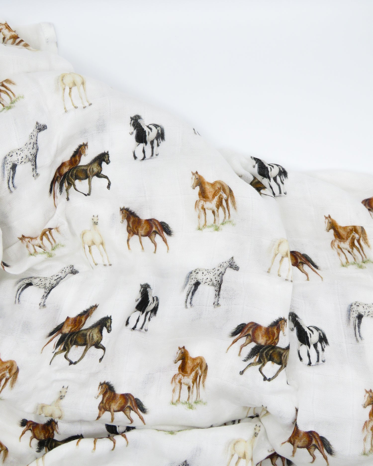 Harbor Horse swaddle with painted horse designs, made of soft white 30% organic cotton and 70% bamboo, perfect for wrapping a newborn and adding to a hospital bag.