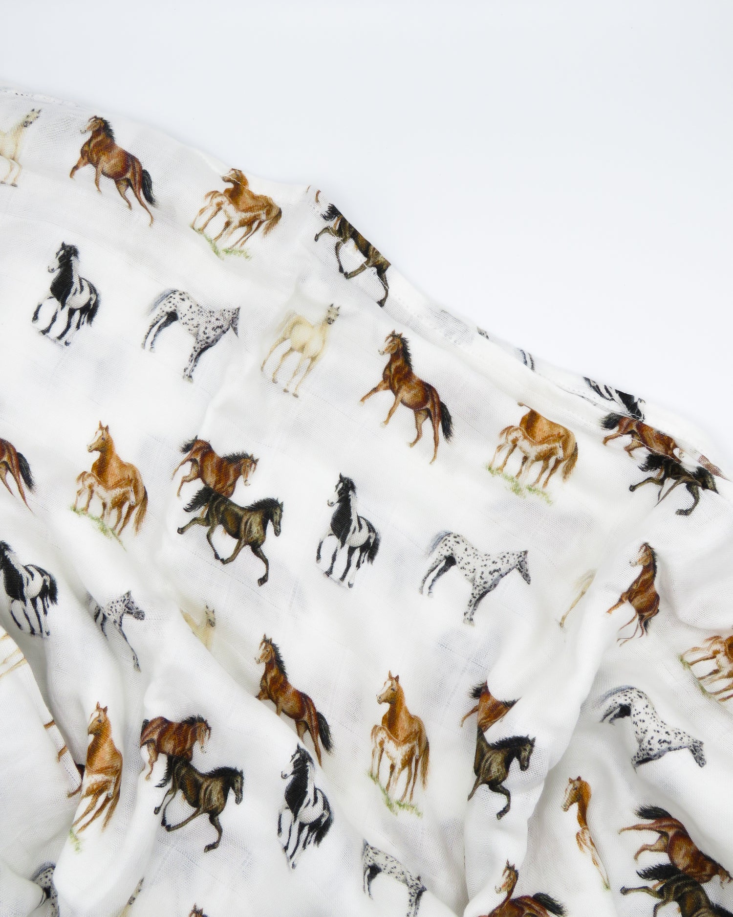 Harbor Horse swaddle with painted horse designs, made of soft white 30% organic cotton and 70% bamboo, perfect for wrapping a newborn and adding to a hospital bag.
