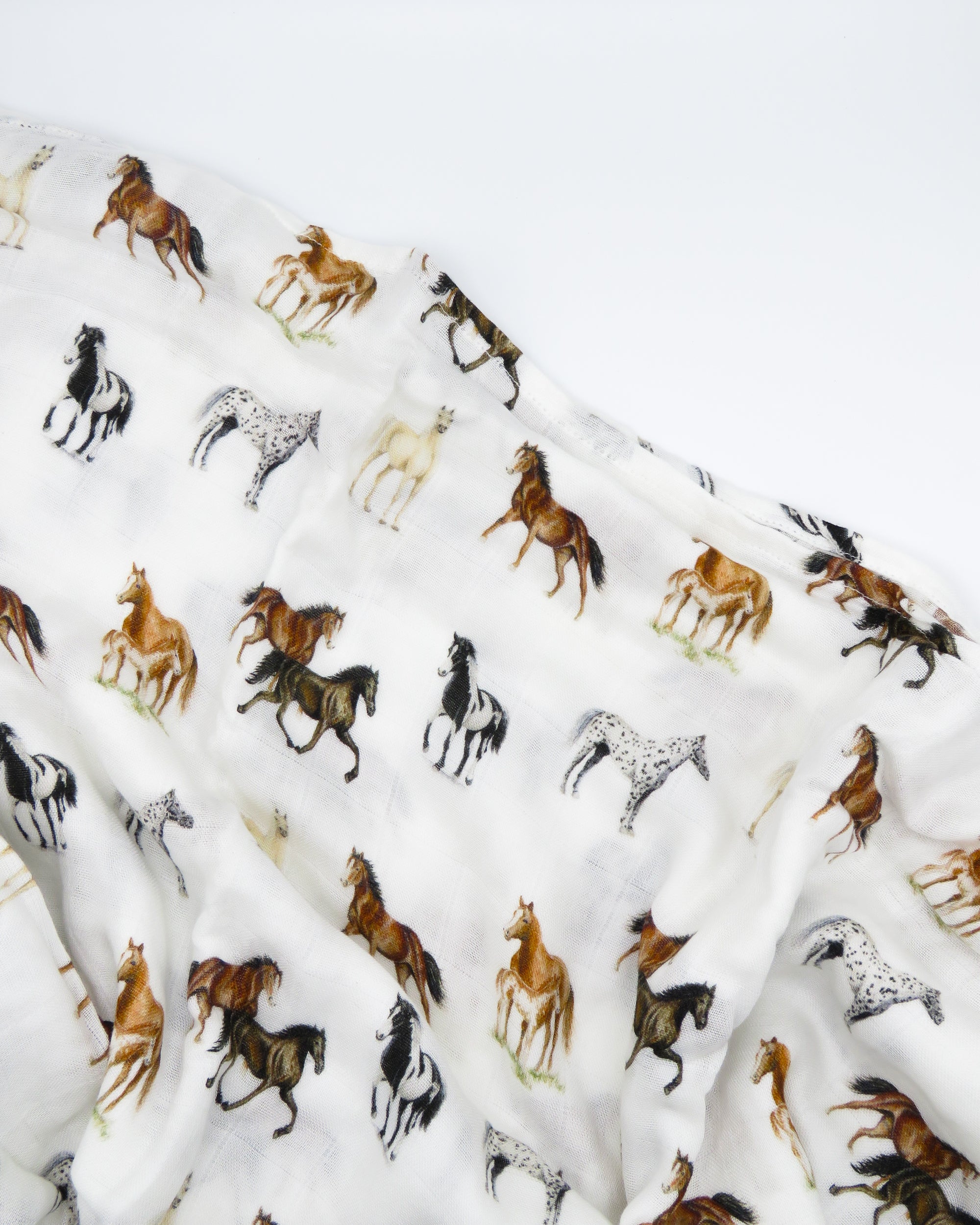 Harbor Horse swaddle with painted horse designs, made of soft white 30% organic cotton and 70% bamboo, perfect for wrapping a newborn and adding to a hospital bag.