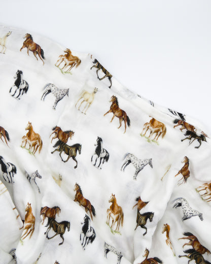Harbor Horse swaddle with painted horse designs, made of soft white 30% organic cotton and 70% bamboo, perfect for wrapping a newborn and adding to a hospital bag.
