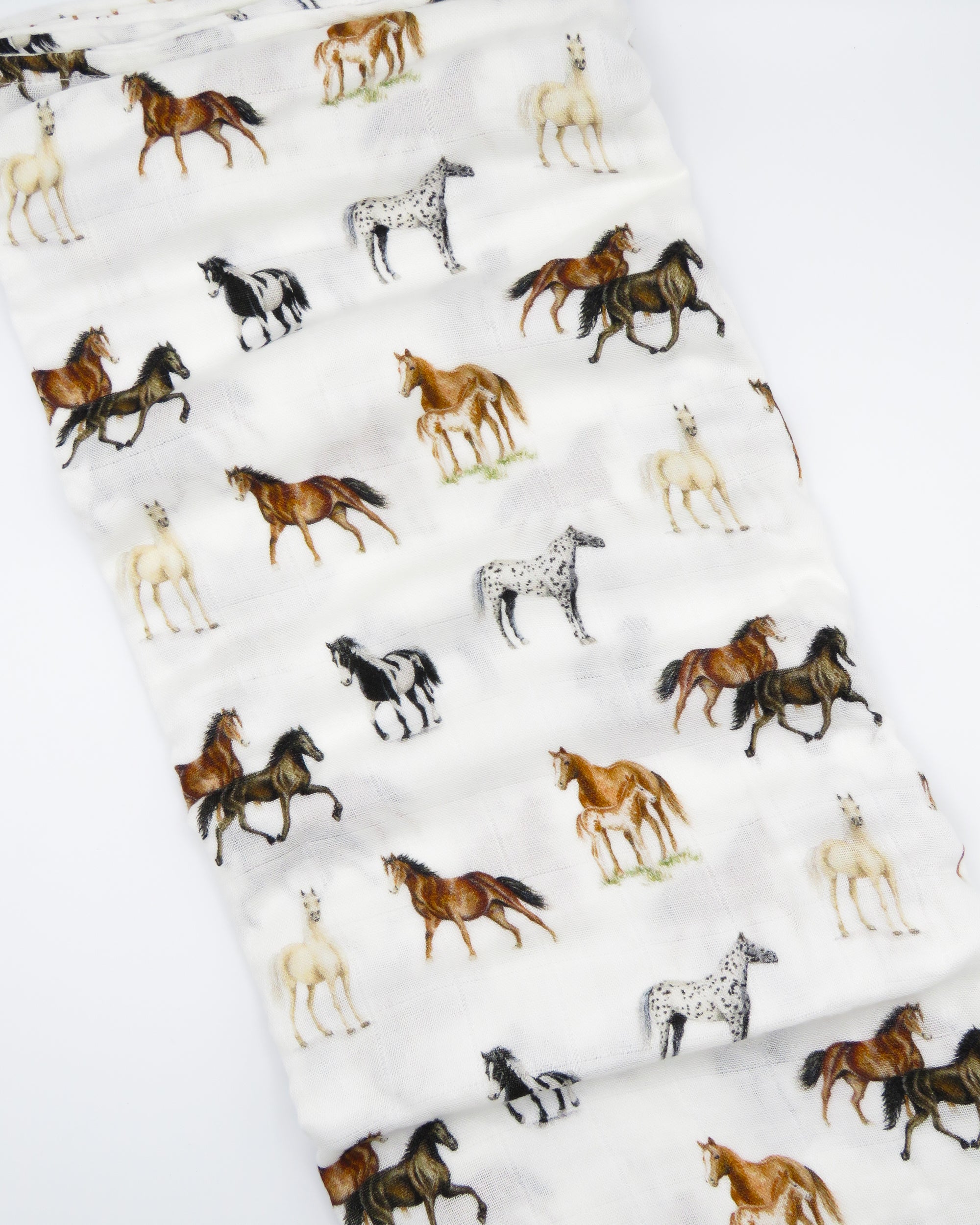 Harbor Horse swaddle with painted horse designs, made of soft white 30% organic cotton and 70% bamboo, perfect for wrapping a newborn and adding to a hospital bag.