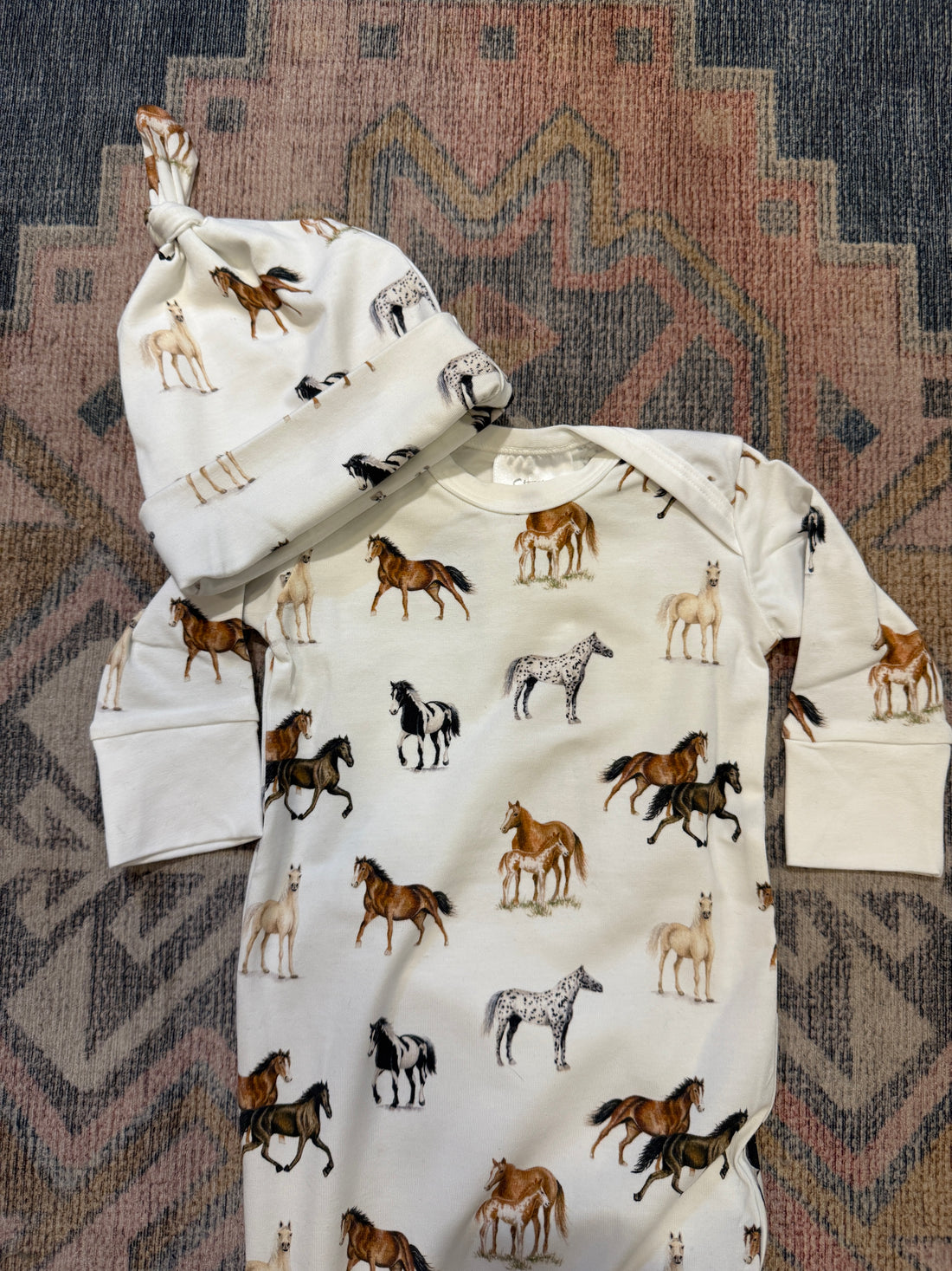 Harbor Horses Newborn Gown and Hat set printed on soft white fabric, featuring a charming harbor horses pattern. This cozy newborn outfit includes a matching hat and gown, making it a newborn’s new favorite and a perfect addition to your hospital bag.
