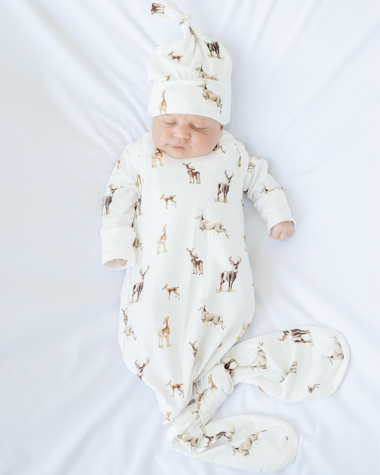 Little Fawn Big Yawn Deer newborn gown and matching hat, made from soft white cotton jersey with bottom flaps for knotting, cozy and perfect for your hospital bag. Worn by a sleeping baby.