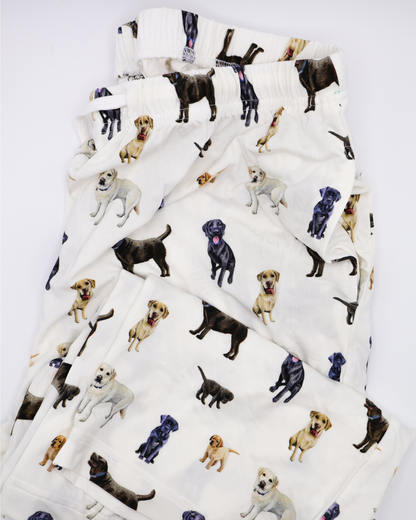 White adult pants with an all-over pattern of black, chocolate, and yellow labs, shown folded on a white background.