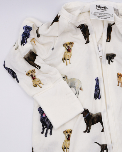 A convertible zip footies for babies, featuring an all-over print of black, chocolate and yellow labs. Displayed flat on a white background.