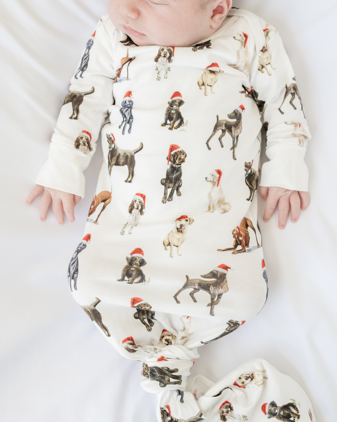 Comfy newborn gown and hat set featuring cute Santa dog prints, perfect for baby’s first Christmas