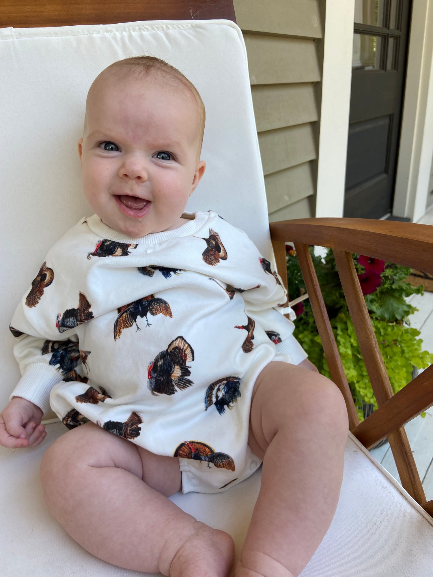 Baby wearing a cozy Turkey Trot sweatshirt romper made from organic fabric
