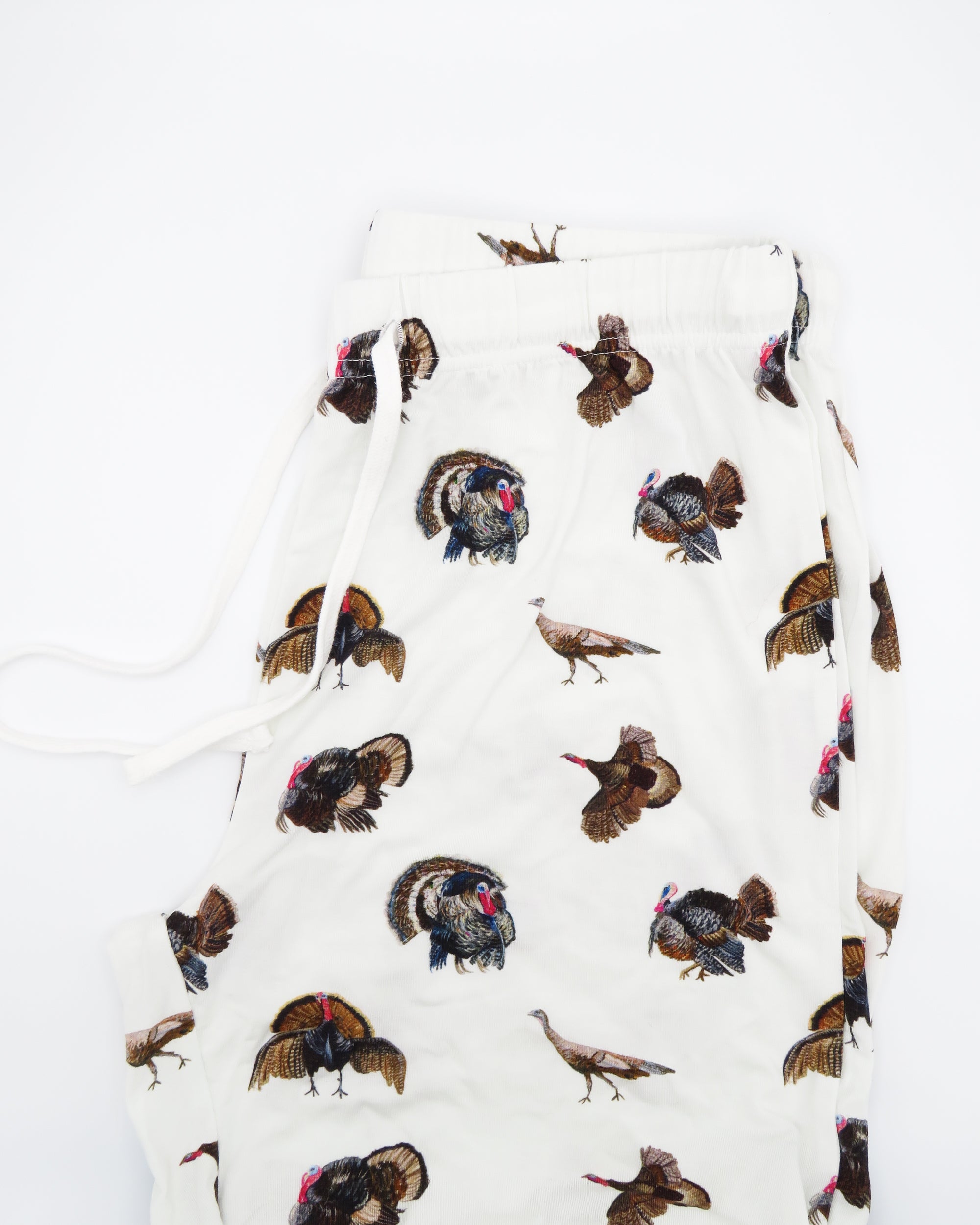 Turkey Trot adult pajama pants in soft white bamboo spandex with a turkey print, cozy and stretchy for loungewear or sleepwear. Displayed flat on a white background.