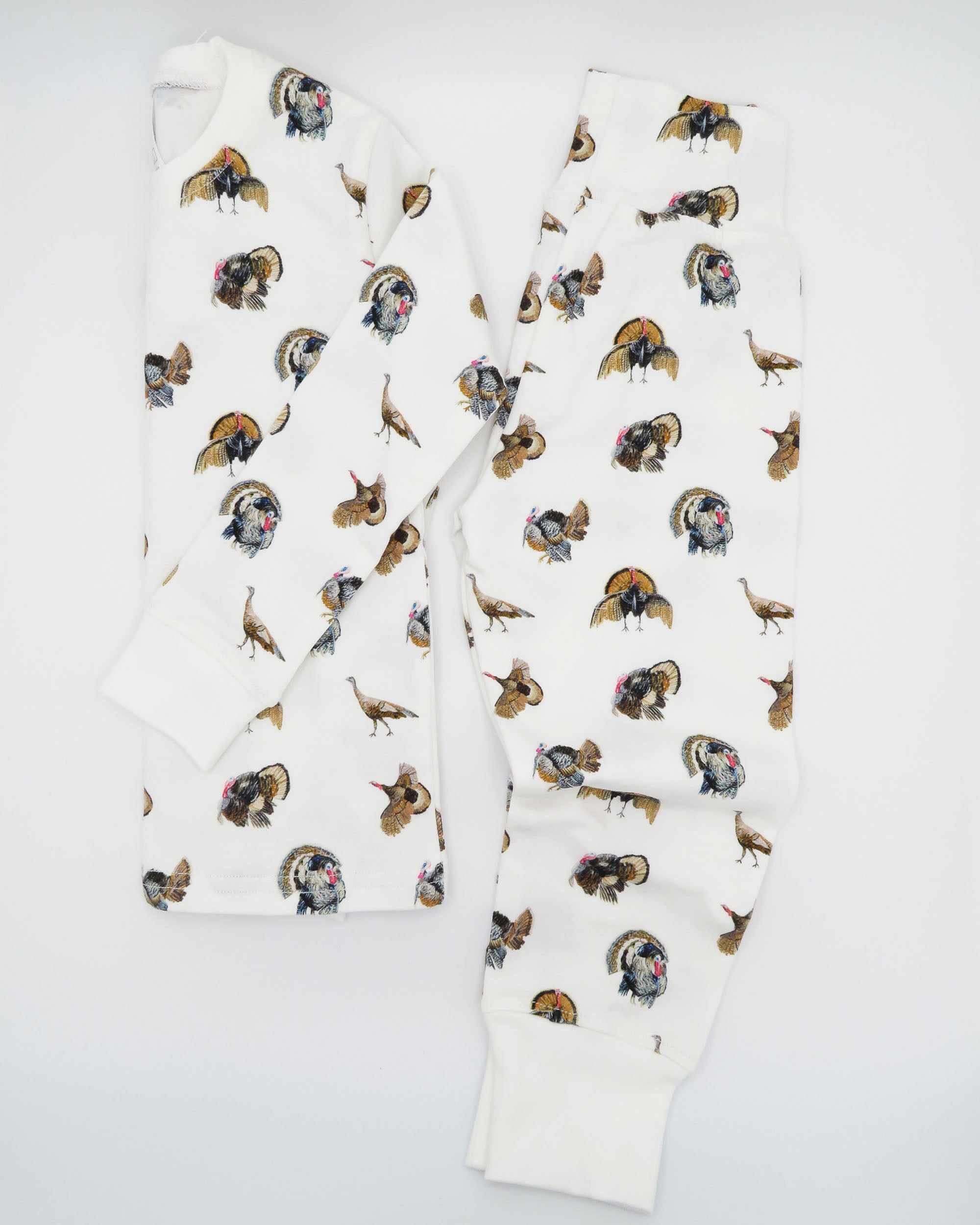 Turkey Trot print pajama for kids, high-quality, cozy, and soft. Perfect for sleepwear or loungewear indoors and outdoors, printed on soft white fabric. Displayed flat on white background.