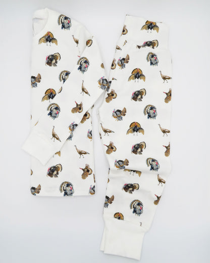 Turkey Trot print pajama for kids, high-quality, cozy, and soft. Perfect for sleepwear or loungewear indoors and outdoors, printed on soft white fabric. Displayed flat on white background.