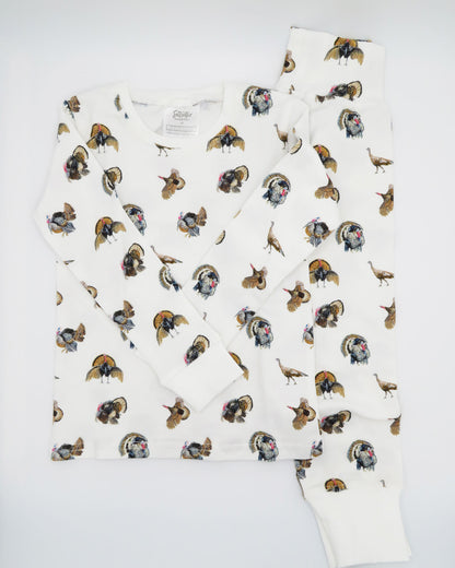Turkey Trot print pajama for kids, high-quality, cozy, and soft. Perfect for sleepwear or loungewear indoors and outdoors, printed on soft white fabric. Displayed flat on white background.